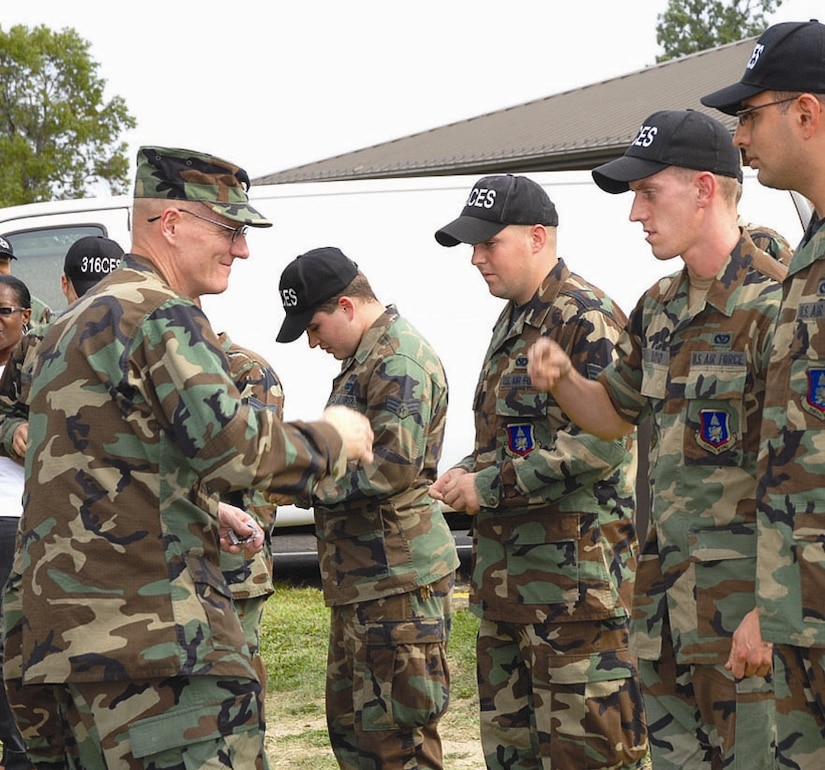 Several members of the 316th Civil Engineer Squadron were coined recently by Col. Paul Ackerley, 316th Wing commander, for their quick response to design and connect an automatic back-up generator to provide emergency power to the temporary command post. (US Air Force/Chuck Tsinnie)