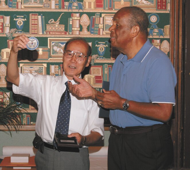 Retired Korean Air Force Col. Bae-Seok Lee, presents a mediallion and certificate of appreciation to retired Air Force Col. Ernest Craigwell, a member of the 6146th Air Force Assistance Group. The 6146th AFAG trained Korean fighter pilots during the Korean War, and Col. Lee credited them with training "the first group of Korean pilots. Most of them became leaders of the Korean Air Force." Skywrighter photo by Christy Webb.