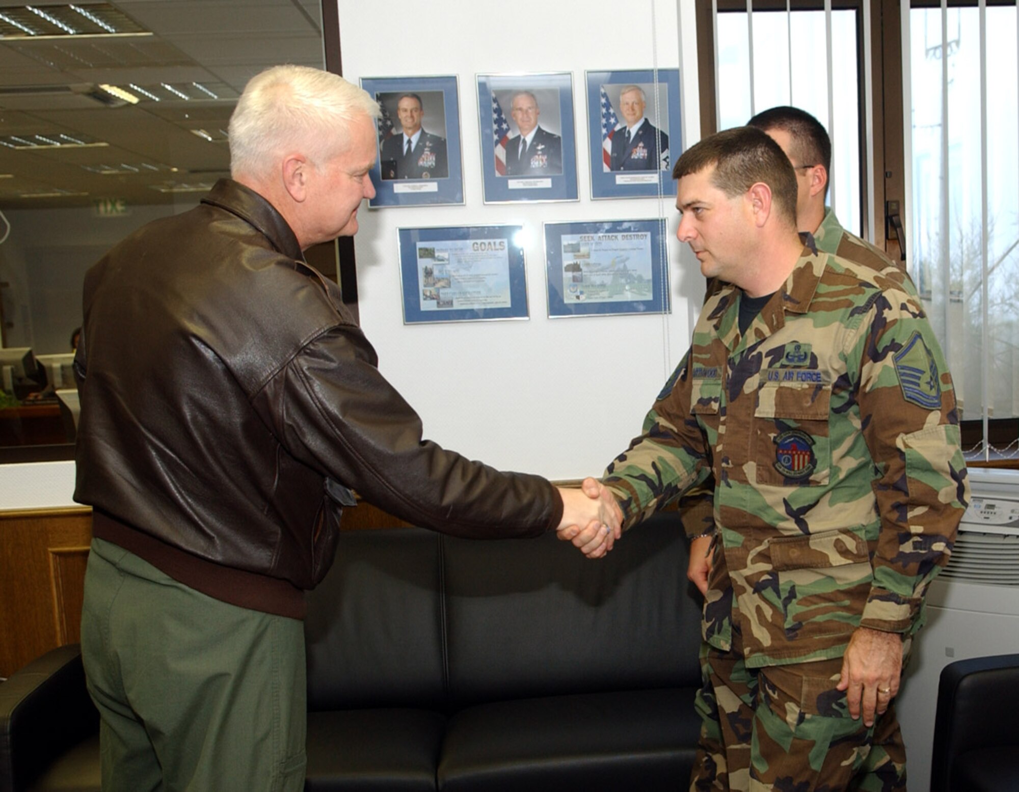 SPANGDAHLEM AIR BASE, Germany -- Lt. Gen. Rod Bishop, 3rd Air Force commander, coins Master Sgt. James Swarthwood, 52nd Civil Engineer Squadron, for his work during a humanitarian deployment to Guinea-Bissau, West Africa. While deployed, Sergeant Swarthwood served on a 10-member team responsible for providing local de-miners in battle area clearance and unexploded ordnance demolition. (U.S. Air Force photo/Airman 1st Class Allen Pollard)