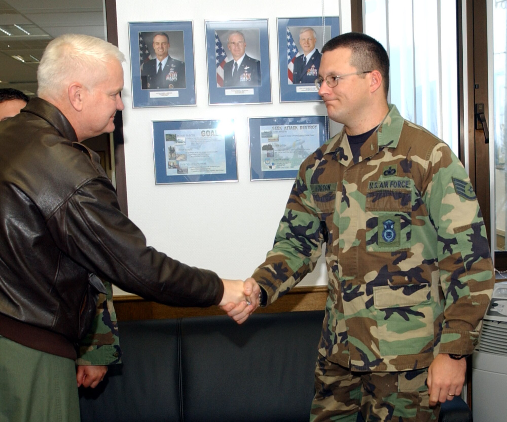 SPANGDAHLEM AIR BASE, Germany -- Lt. Gen. Rod Bishop, 3rd Air Force commander, coins Staff Sgt. Hudson, 52nd Security Forces Squadron, for his work during a humanitarian deployment to Guinea-Bissau, West Africa. While deployed, Sergeant Hudson served on a 10-member team responsible for providing local de-miners in battle area clearance and unexploded ordnance demolition. (U.S. Air Force photo/Airman 1st Class Allen Pollard)