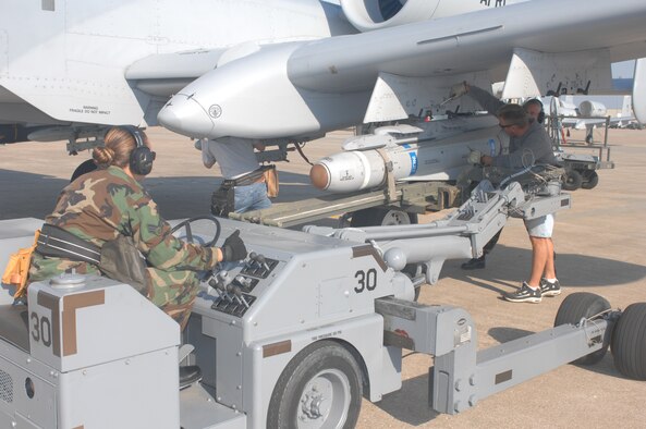 WHITEMAN AIR FORCE BASE, Mo. -- Senior Airman Jennifer Laspino, 442nd Aircraft Maintenance Squadron, adjusts the position of an AGM-65 Maverick on a jammer to line up with an A-10 weapons pylon station. Master Sgt. Edward Coyle and Jim Smitka, both from the 442d AMXS, prepare to lock the missile to the station Sept. 17. Although the missiles are inert, pilots from the 442nd Fighter Wing fly training sorties with the missiles attached to practice targeting techniques. (U.S. Air Force photo/Tech. Sgt. Samuel A. Park) 
