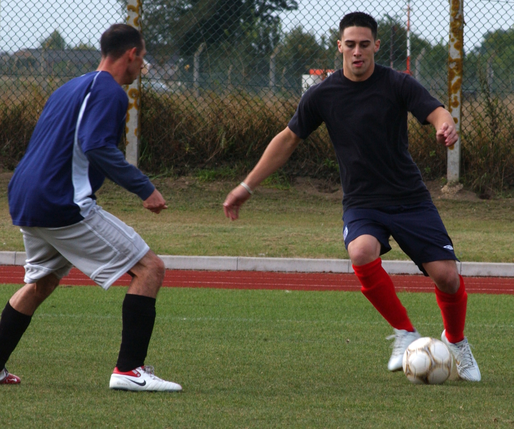 Kris Hyde, the 100th Logistics Readiness Squadron coach, tries to pass Jared Flores, 95th Reconnaissance Squadron player, during outdoor intramural soccer at RAF Mildenhall, Sept. 19. (U.S. Air Force photo by Airman Brad Smith)