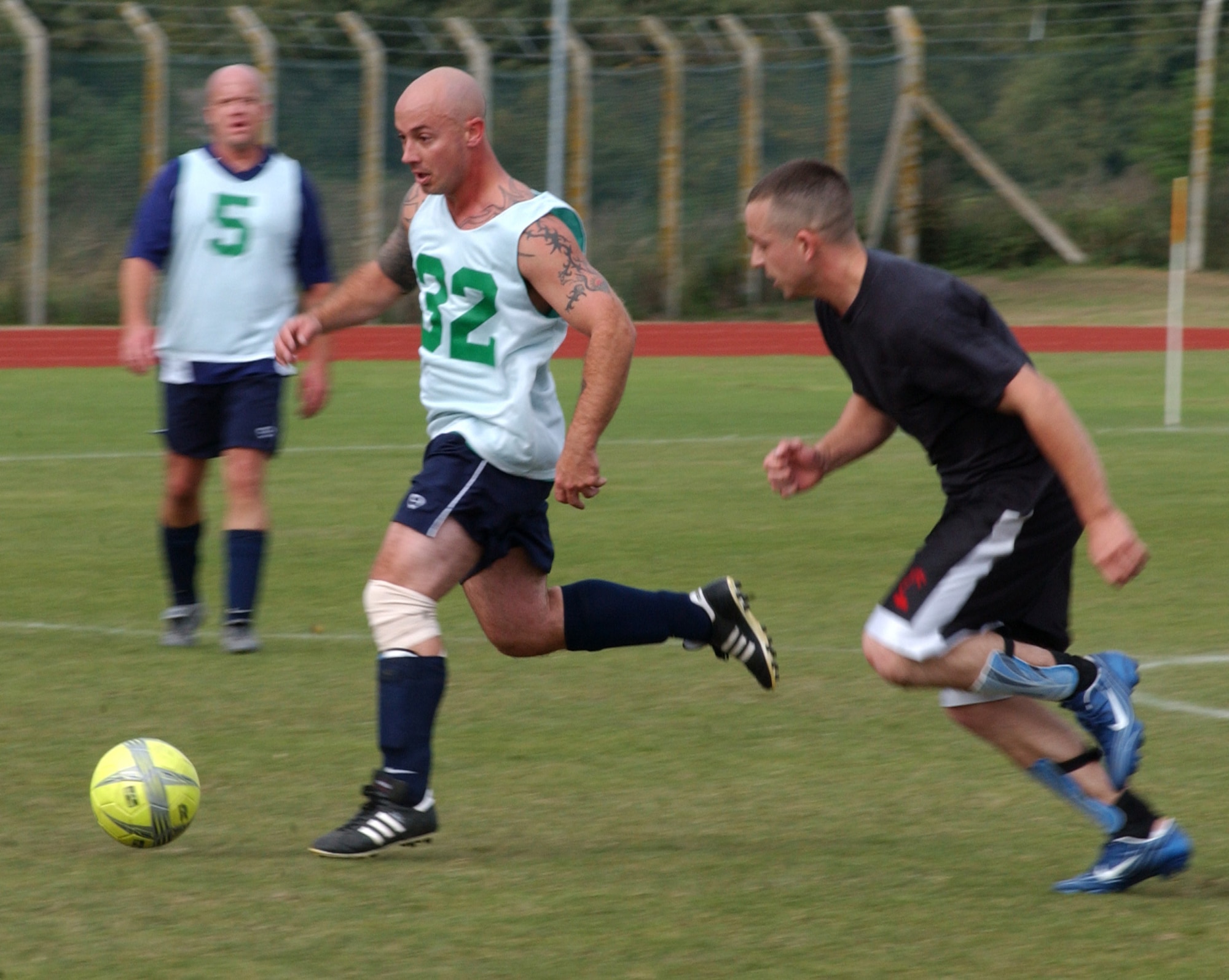 Richard Christensen (32), coach for the 95th Reconnaissance Squadron runs pass Dustin Rice, 100th Logistics Readiness Squadron, in the second half of the outdoor intramural soccer game  at RAF Mildenhall, Sept. 19. (U.S. Air Force photo by Airman Brad Smith)