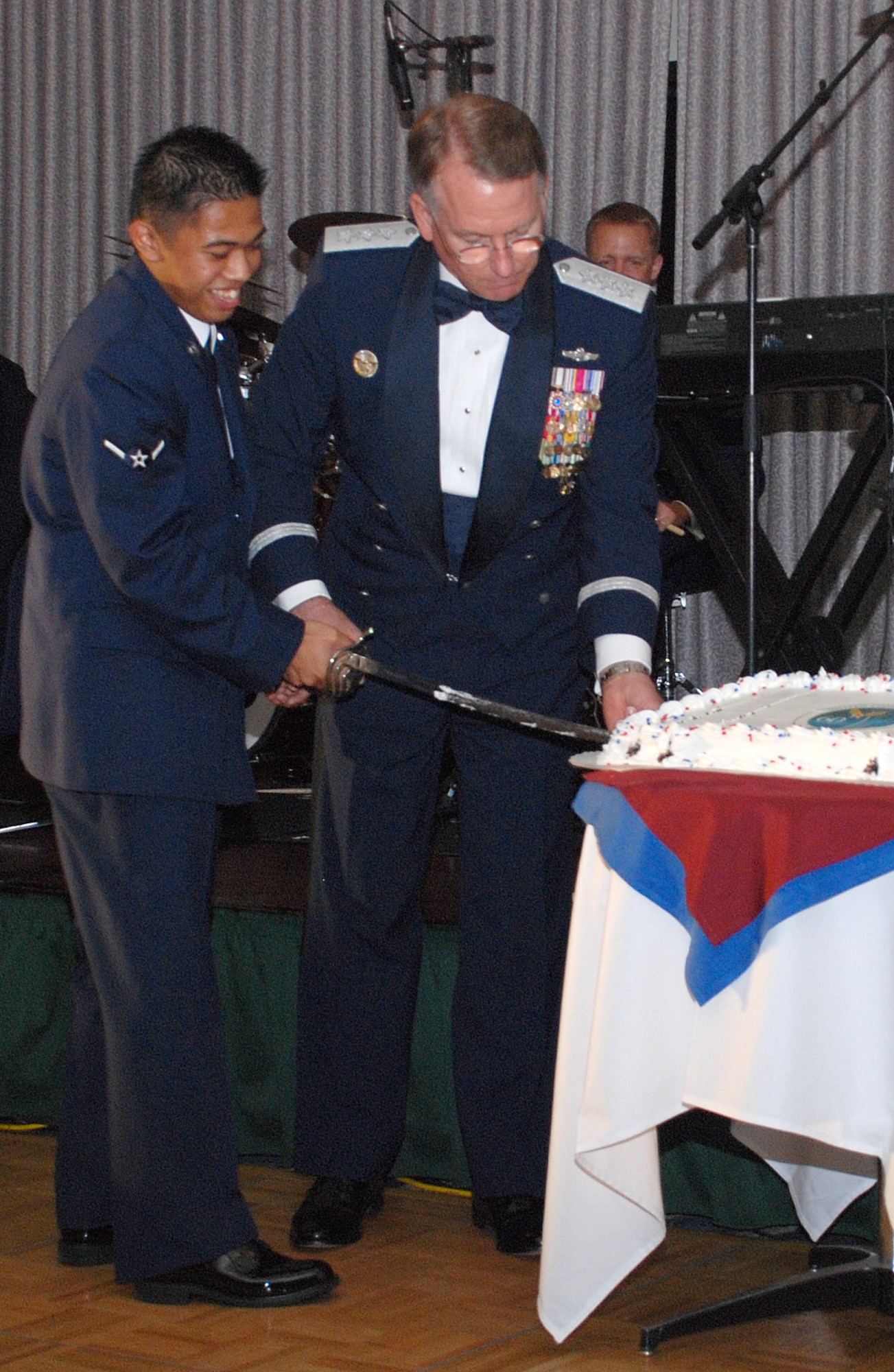 Lt. Gen. John Bradley, USAF Reserve Command commander, and Airman Mark Canto, 305th Operations Group, cut the birthday cake at McGuire's celebration of the Air Force's 60th Anniversary held Sept. 15. The event featured music performed by the U.S. Air Force band "Afterburner". (U.S. Air Force photo/Capt. Anthony Duggan.)