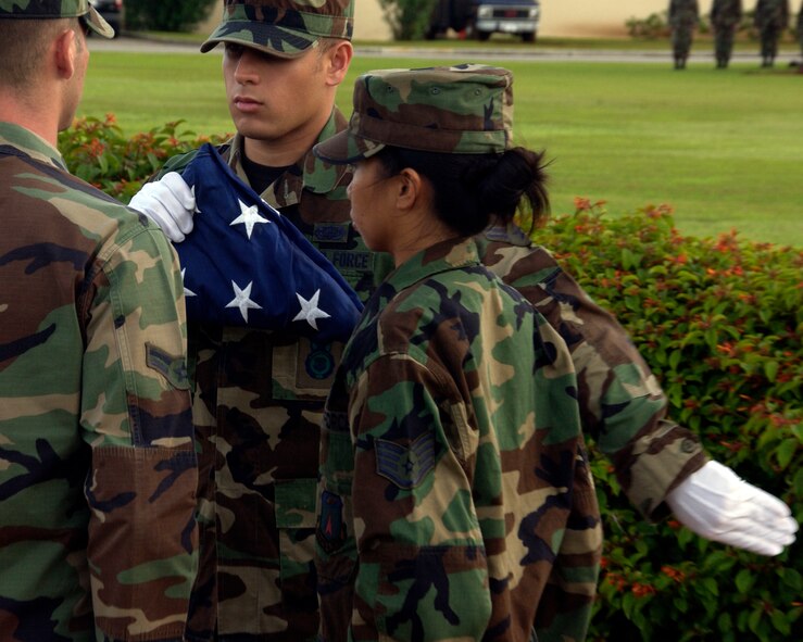 ANDERSEN AIR FORCE BASE GUAM, Airman First Class Justin Bailey, 736 Security Forces Squadron, checks the tight crease in the flag while retiring the colors during the Andersen Air Force Base's POW MIA retreat ceremony. Andersen Air Force base honors the fallen Prisoners Of War and those still Missing In Action with their annual remembrance ceremony.(U.S. Air Force Photo by Technical Sergeant Michael Boquette)(RELEASED)