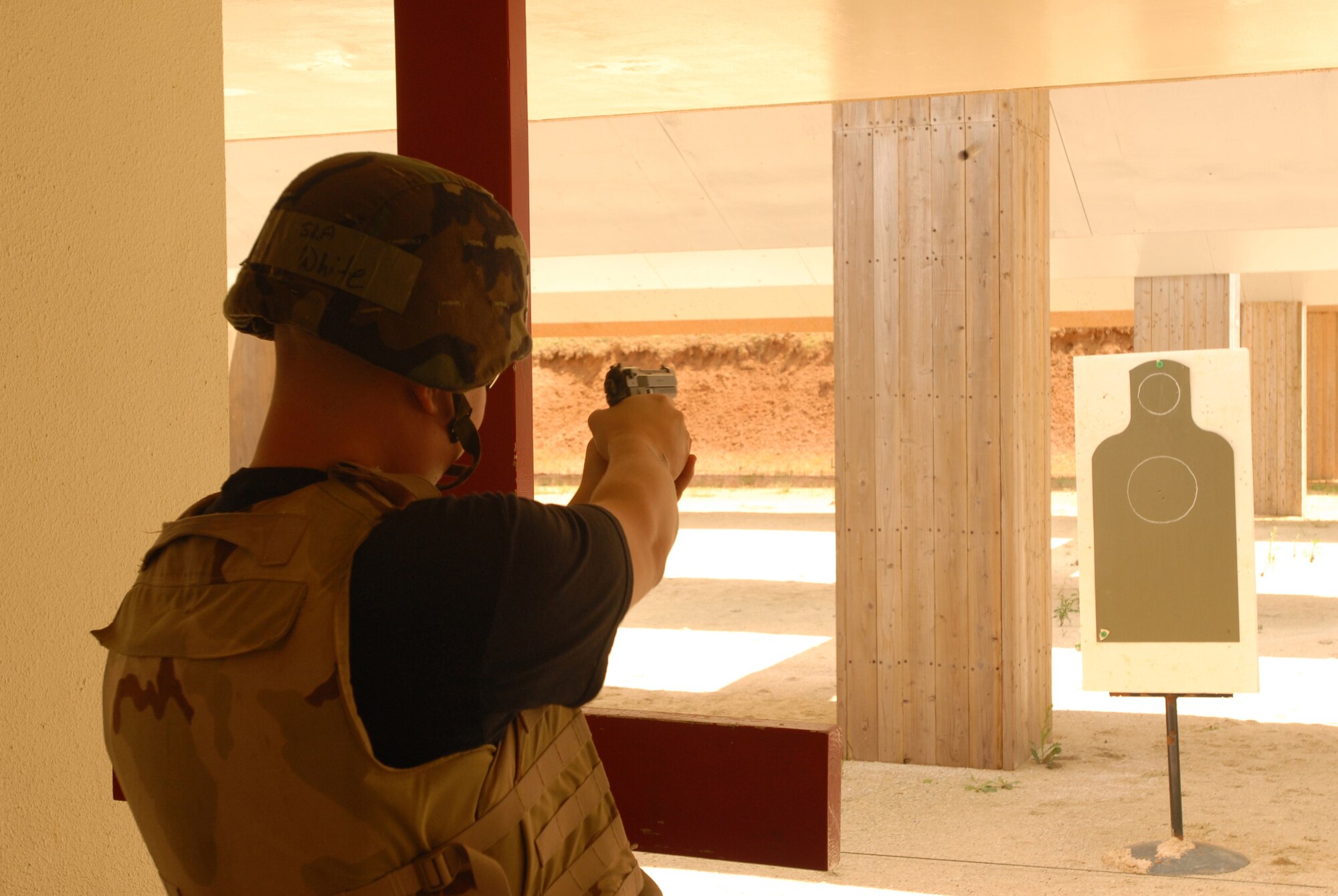 Senior Airmen Nathan White puts M9 pistol rounds down range toward a practice target before firing a series of timed shots during a combat arms qualification course at Kadena Air Force Base, Japan, Sept.  20, 2007.  Security forces Airmen must qualify on the M9 annually. Airman White is assigned to the 18th Security Forces Squadron.  (U.S. Air Force photo/Airman 1st Class Ryan Ivacic)