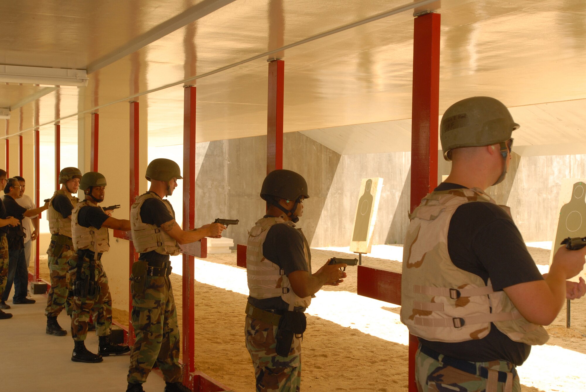 Airmen from the 18 Security Forces Squadron step up to the firing line with their M-9 pistols  before firing a series of timed shots during a combat arms qualification course at Kadena Air Force Base, Japan, Sept.  20, 2007.  Security forces Airmen must qualify on the M9 annually. (U.S. Air Force photo/Airman 1st Class Ryan Ivacic) 