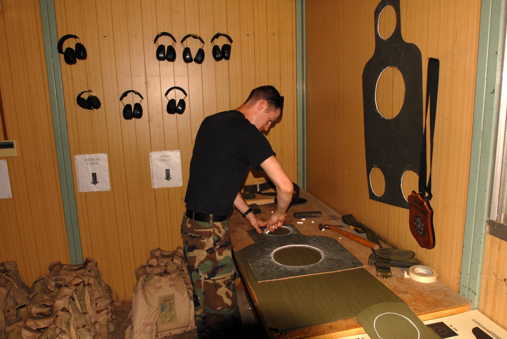 Staff Sgt. Grant Holder a Combat Arms Instructor from the 18 Security Forces Squadron draws rings on a target during a combat arms qualification course at Kadena Air Force Base, Japan, Sept.  20, 2007.  Security forces Airmen must qualify on the M9 annually. Sergeant Holder is assigned to the 18th Security Forces Squadron.  (U.S. Air Force photo/Airman 1st Class Ryan Ivacic)