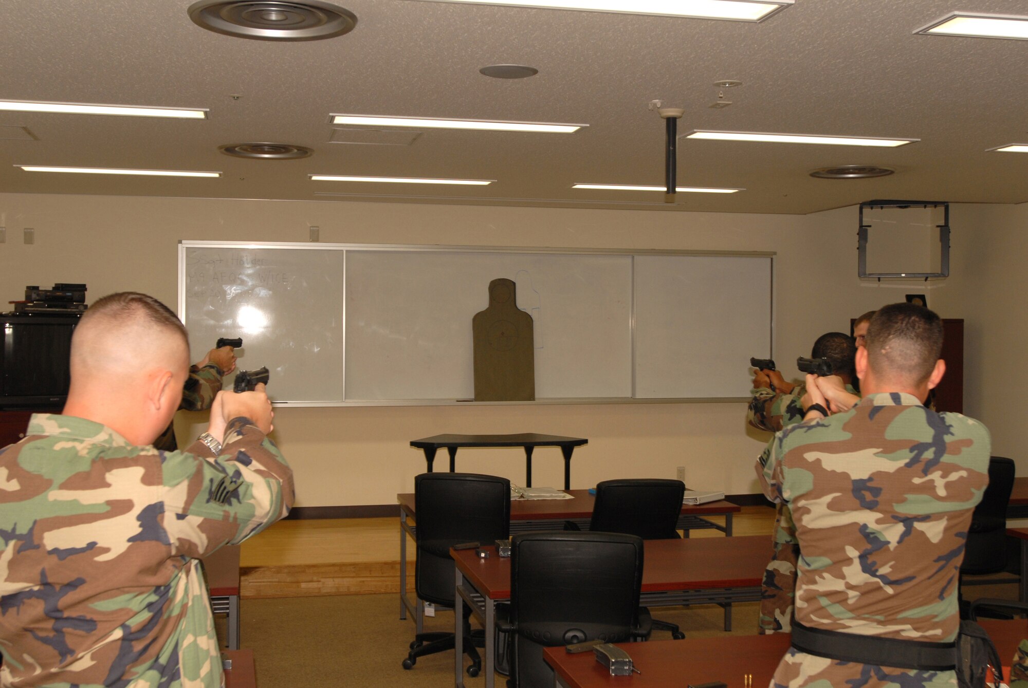 Airmen from the 18th Security Forces Squadron practice aiming at a target during the classroom portion of the  combat arms qualification course at Kadena Air Force Base, Japan, Sept.  20, 2007.  Security forces Airmen must qualify on the M9 annually.  (U.S. Air Force photo/Airman 1st Class Ryan Ivacic)