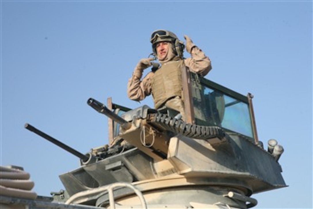 A U.S. Marine with 2nd Assault Amphibian Battalion scans the surrounding area from the turret of an amphibious assault vehicle in Saqlawiyah, Iraq, on Sept. 14, 2007. 