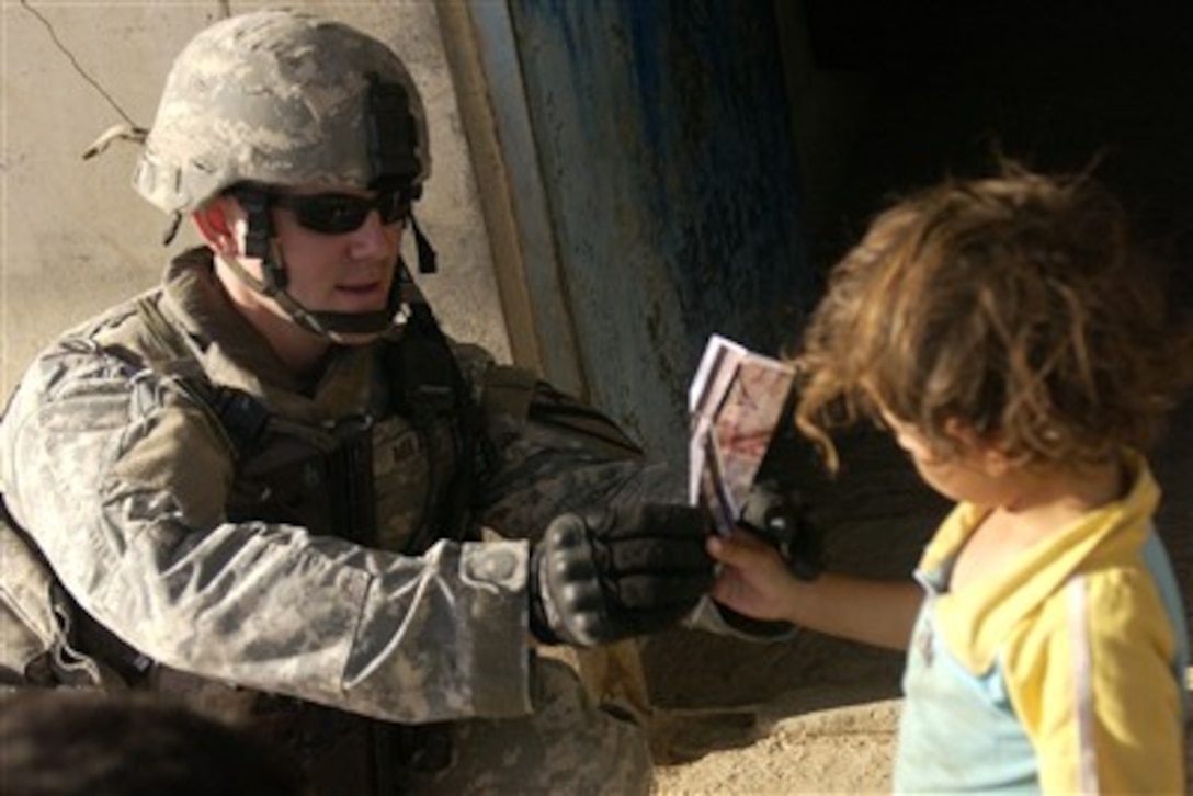 U.S. Army 1st Lt. Michael Miller shows an Iraqi child how to make a paper airplane during operations on the outskirts of Mosul, Iraq, on Sept. 17, 2007.  Miller is assigned to Delta Company, 27th Cavalry Regiment, 4th Brigade Combat Team, 1st Cavalry Division.  DoD photo by Airman 1st Class Christopher Hubenthal, U.S. Air Force.  (Released)