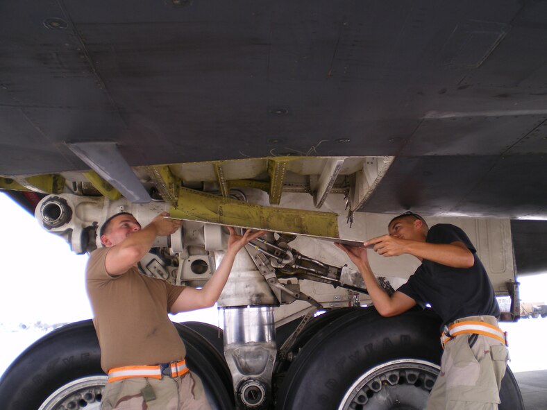 SOUTHWEST ASIA -- Staff Sgt. Roberto Peralta and Senior Airman Justin Shepard, 379th Expeditionary Aircraft Maintenance Squadron, install a recently repaired panel on a B-1 Lancer. Airmen from the 379th EAMXS performed depot-level maintenance here to avoid loss of mission effectiveness. (U.S. Air Force photo/Lt. Col. Scott Fike)