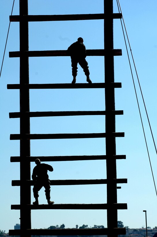 Company F Marines scale the Stairway to Heaven. To overcome the obstacle, Marines must climb to the top log, roll over to the other side, and then climb back to the ground.