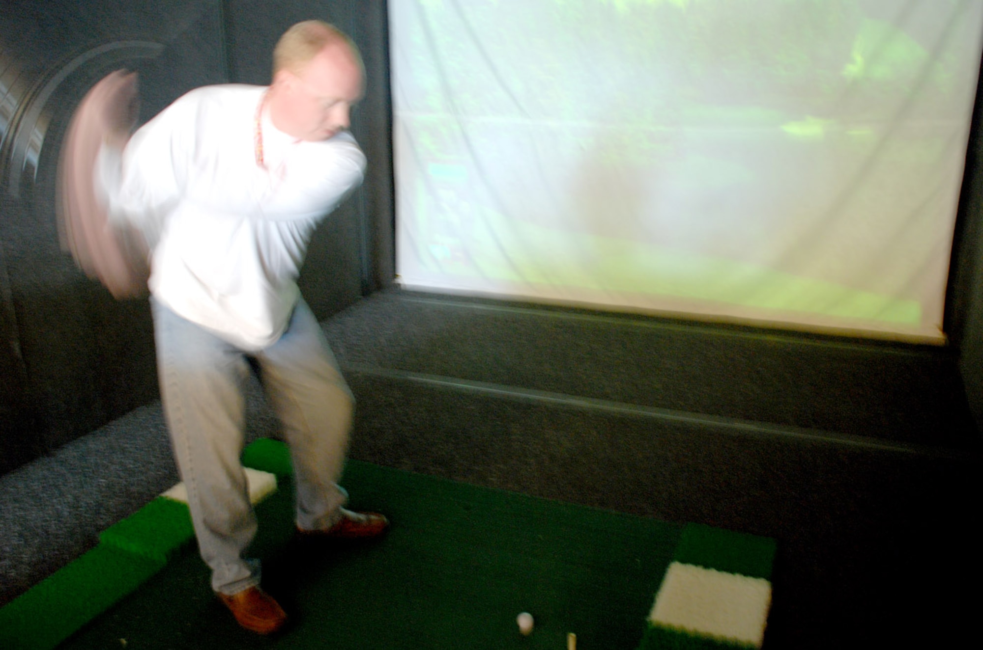 Carroll Sharratt, golf club general manager, demonstrates the many functions of the golf simulator located at the Warren Golf Club on base Sept. 13. It’s a state-of-the-art machine with 18 different golf courses (Photo by Airman 1st Class Daryl Knee).