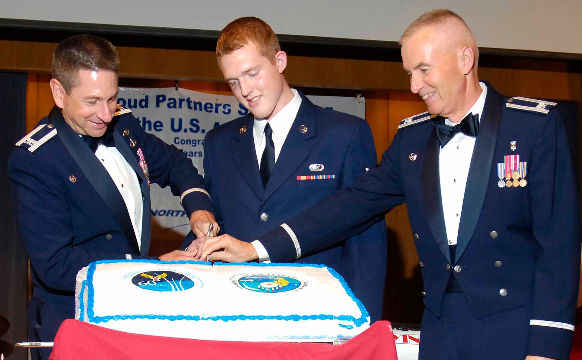 Col. Mark Correll, 72nd Air Base Wing and Tinker installation commander, Airman 1st Class Ross Brow, 72nd Mission Support Group, and Col. Roger Goetz, 72nd Medical Group commander, from left, cut the cake during the ball. Airman Brow was the youngest and Colonel Goetz was the oldest at the ball, a ceremony tradition. (Air Force photo by Dave Faytinger)