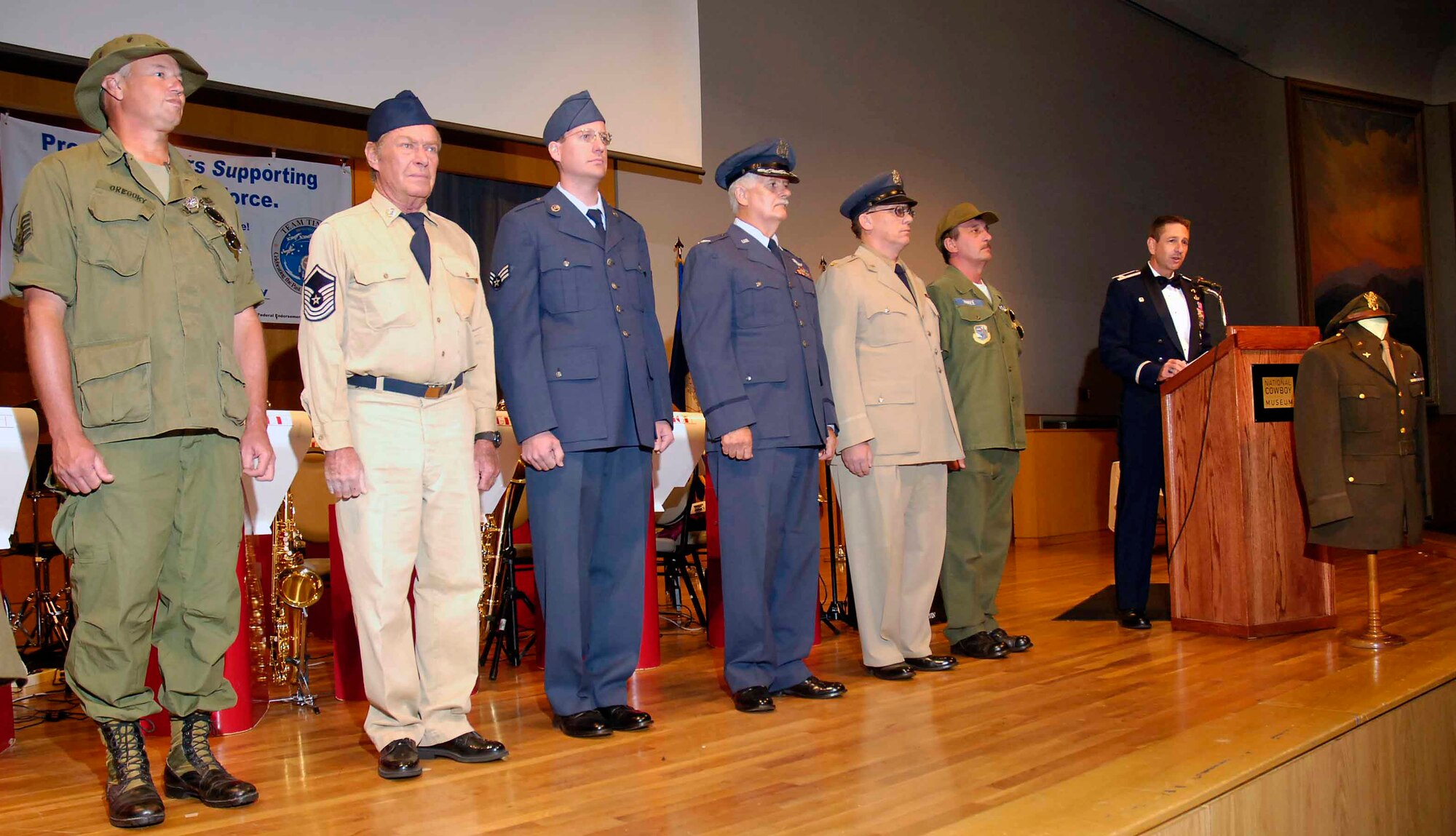 Representing the history of the military, members of the 45th Infantry Division Museum line the stage in vintage uniforms for the Air Force Ball.  Col. Mark Correll, 72nd Air Base Wing and installation commander, talks about 60th anniversary of the Air Force during the program. (Air Force photo by Dave Faytinger)