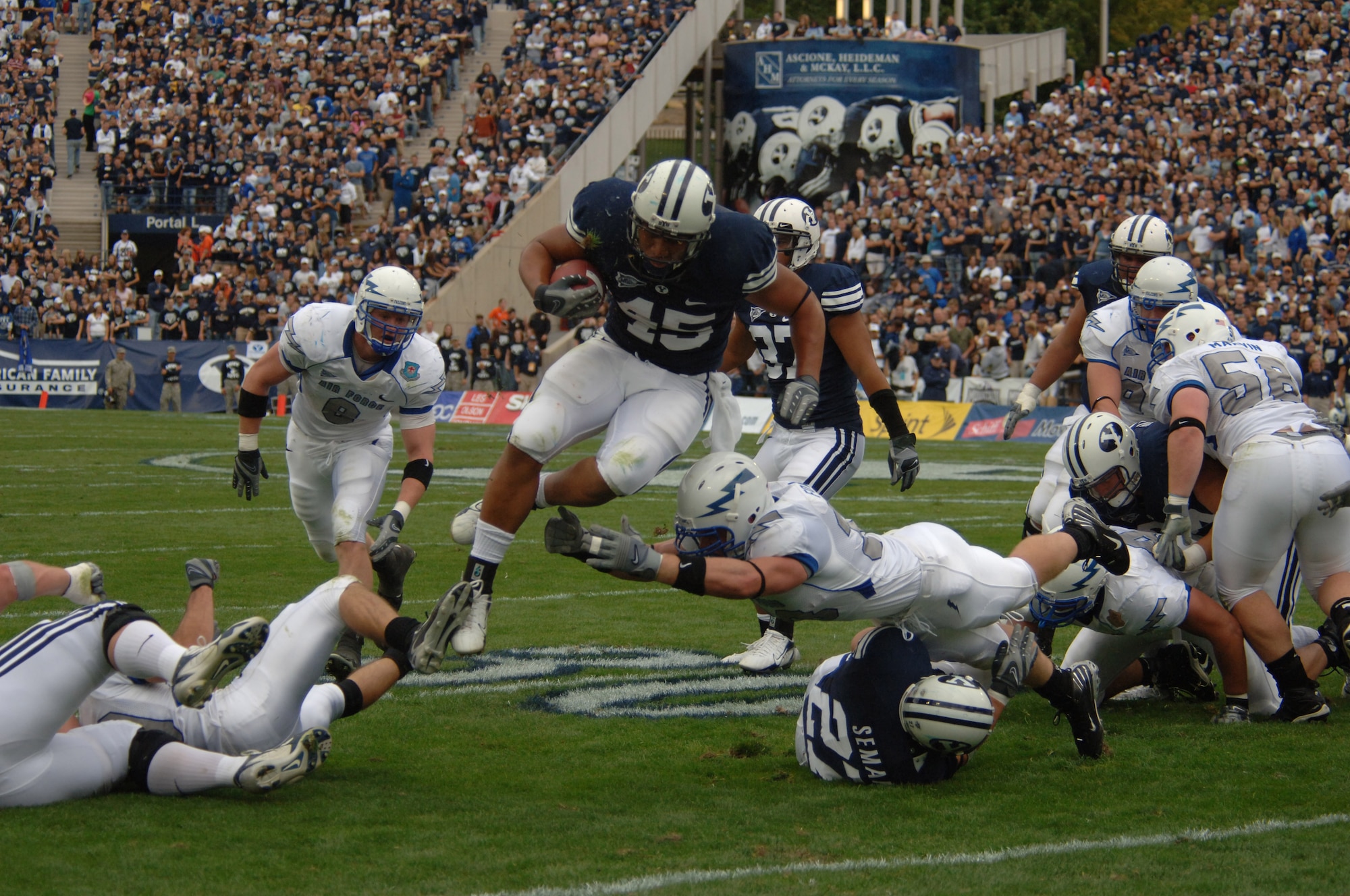 Air Force linebacker Drew Fowler reaches for leaping Brigham Young running back Harvey Unga during BYU's 31-6 win over the Falcons Sept. 22 in Provo, Utah. Unga ran for a game-high 111 yards on 22 carries, averaging five yards per carry. (U.S. Air Force photo/John Van Winkle) 

