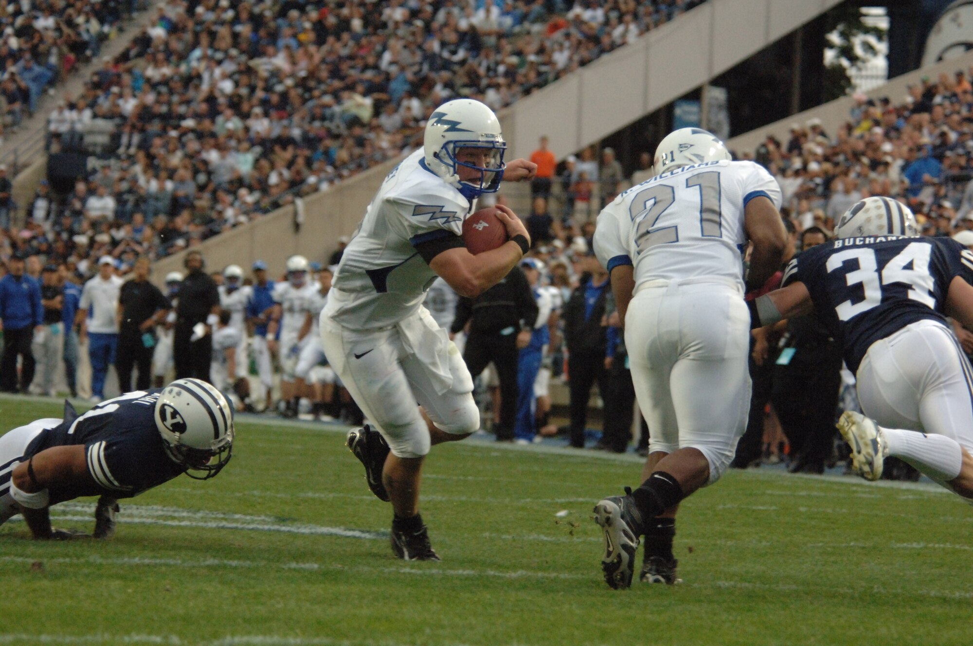 Air Force quarterback Shaun Carney runs behind a block from fullback Ryan Williams, 21, en route to an 8-yard touchdown during Brigham Young's 31-6 win Sept. 22 in Provo, Utah. Carney's TD extended the Falcons consecutive game-scoring streak to 172 games. (U.S. Air Force photo/John Van Winkle) 
