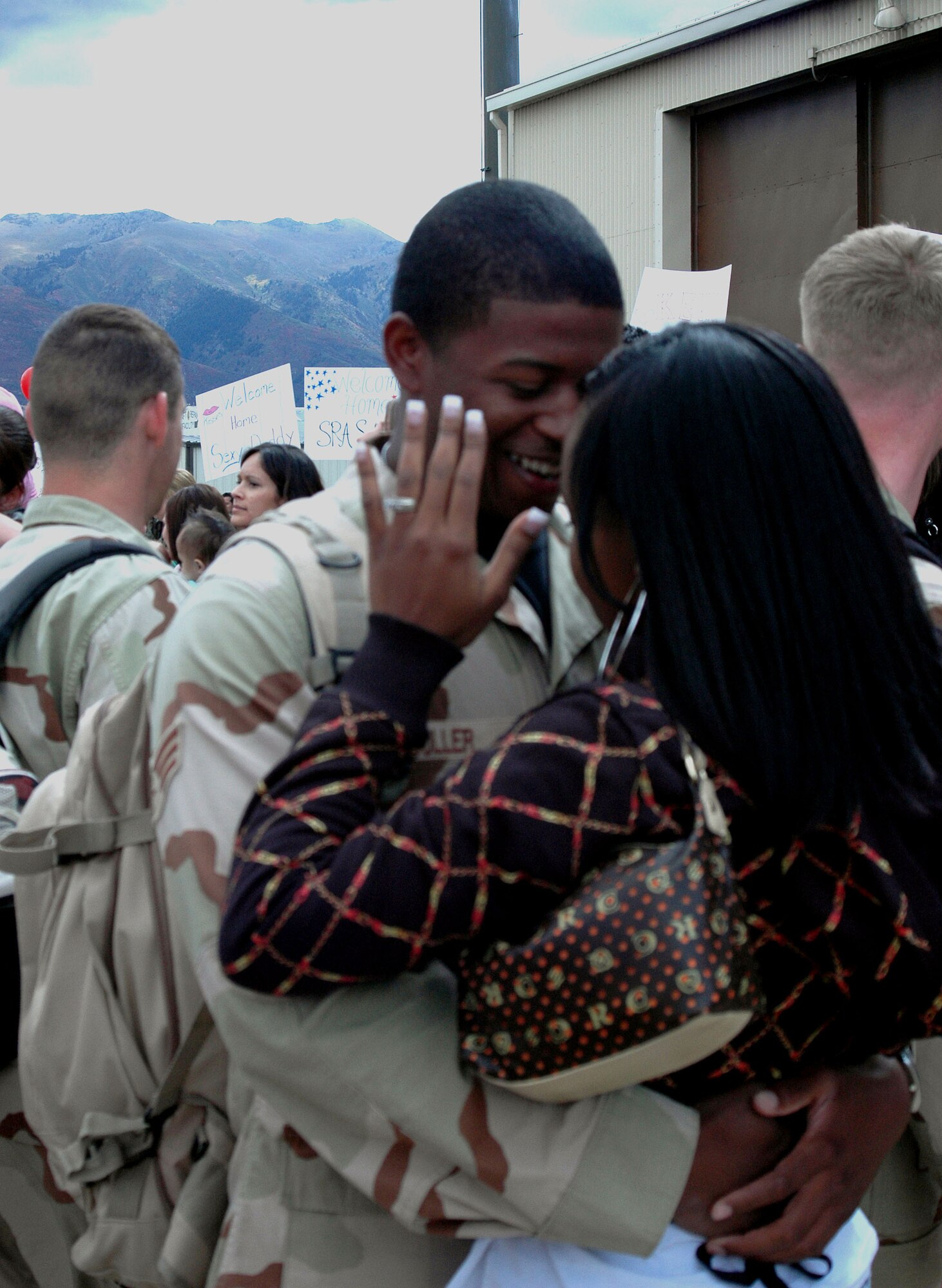 Senior Airman Gerald Fuller, with the 729th Air Control Squadron, hugs his wife after coming back from a four-month deployment to Balad Air Base, Iraq. 