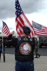 A member of the Patriot Guard Riders fixes his flag while waiting for the arrival of the 729th Air Control Squadron's aircraft to arrive on the flighline. The 729th ACS returned home after a four-month deployment to Balad Air Base, Iraq. 