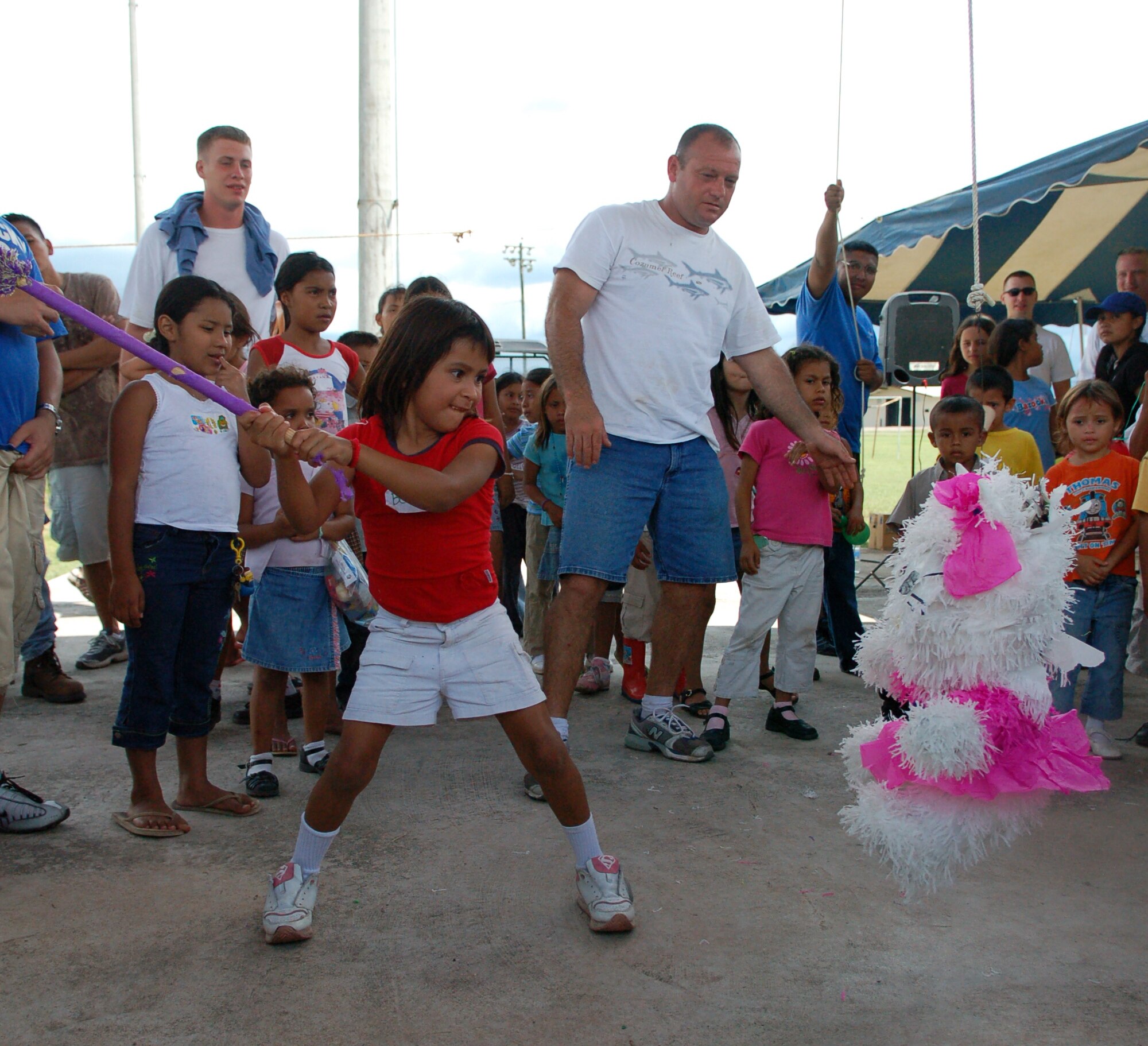 SOTO CANO AIR BASE, Honduras – A young Honduran girl winds up to deliver a crushing blow to a piñata while her friends cheer her on and wait anxiously for their turn to take a swing at it.  Approximately 90 children from Nuestra Señora de Guadalupe Children's Home in Comayagua came out to enjoy the Annual Kids Day celebration September 22.  (U.S. Air Force photo by Staff Sgt. Austin M. May)