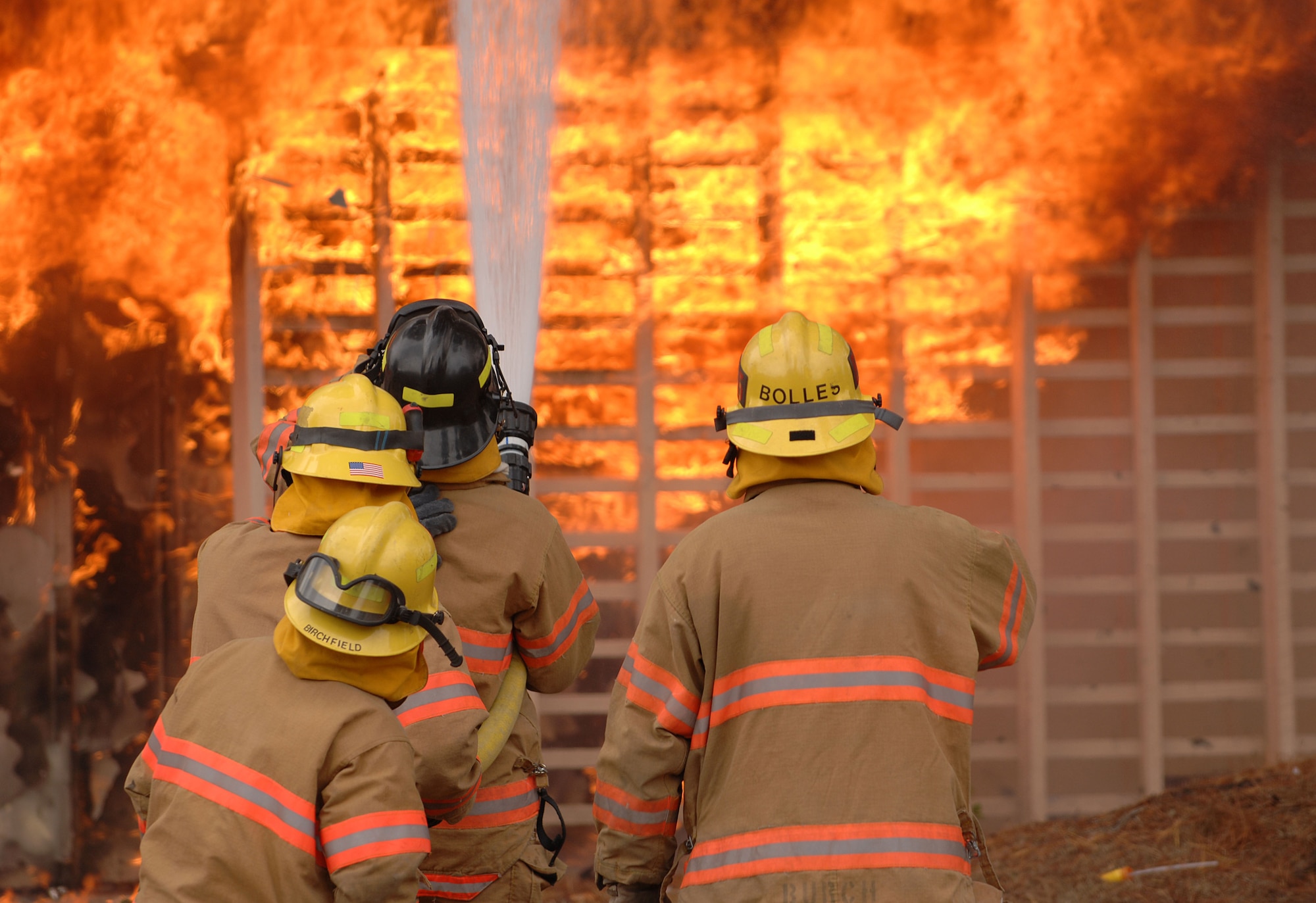 Four Vandenberg fire fighters put out a training fire in east base housing here. The 30th Civil Engineer Squadron Fire Protection Flight have five live training fires planned from 8:30 a.m. to 8 p.m. between Sept. 14 and Oct. 1. The training will consist of live fire training inside a residential structure and will give the firefighters the opportunity to get first-hand knowledge of fire behavior as well as the specific stages of fire growth in safer, controlled environment. (U.S. Air Force photo by Staff Sgt. Vanessa Valentine)