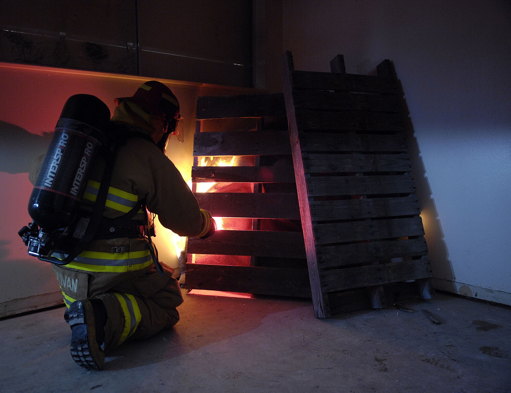 A Vandenberg fire fighter lights an initial fire inside a house in east housing on Sept. 20. The 30th Civil Engineer Squadron Fire Protection Flight have five live training fires planned from 8:30 a.m. to  8 p.m., between Sept. 14 and Oct. 1. The training will consist of live fire training inside a residential structure as well as the opportunity to get first-hand knowledge of fire behavior, specific stages of fire growth in safer, and controlled environment. (U.S. Air Force photo by Staff Sgt. Vanessa Valentine)
