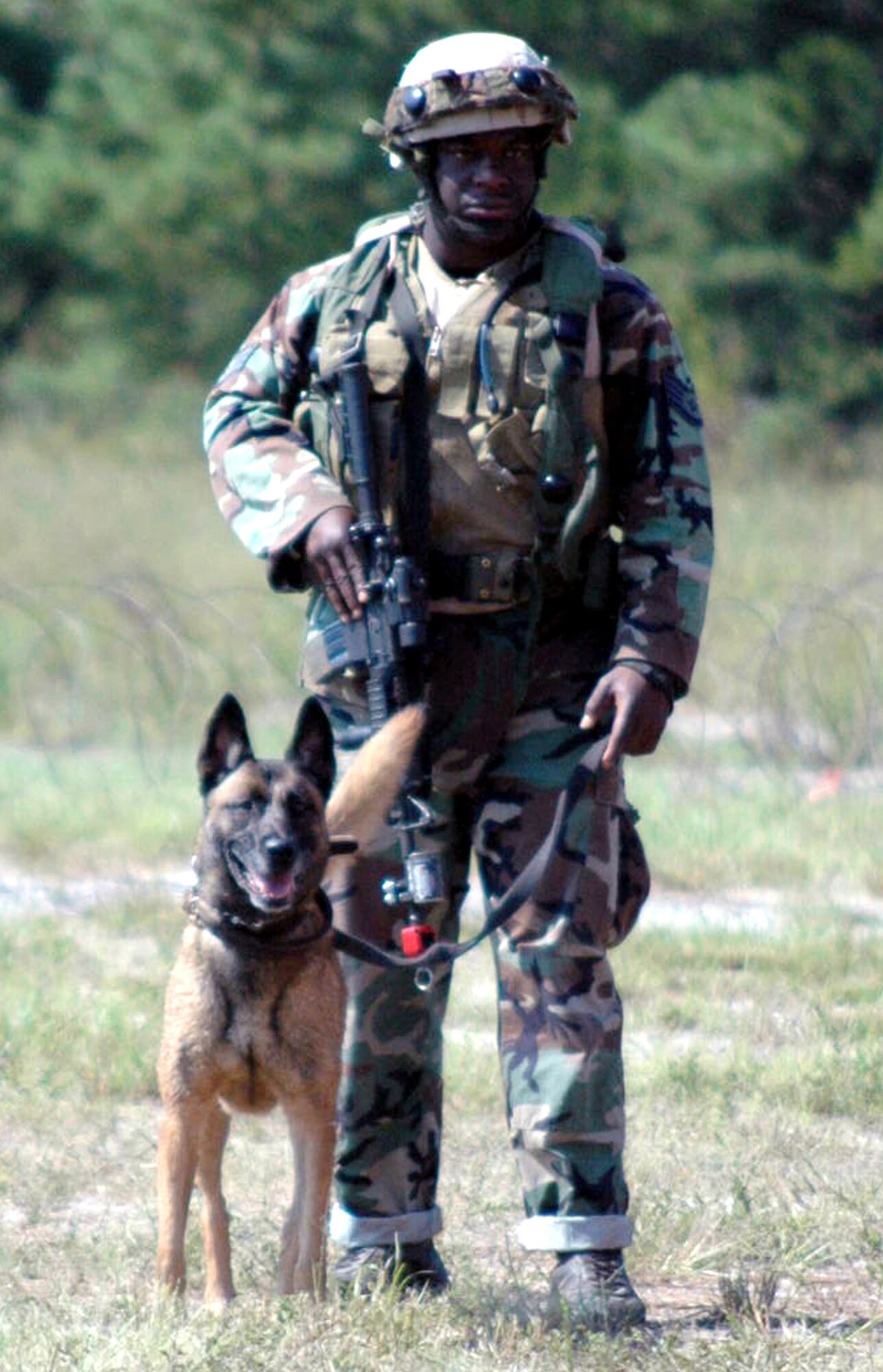 Staff Sgt. Leonard Moses and his military working dog. Loca, participate in a scenario during Air Force Exercise Eagle Flag 07-6 Aug. 29. They were part of the K-9 track for the Air Force Phoenix Warrior Training Course 07-6. Both Eagle Flag and Phoenix Warrior are operated by the U.S. Air Force Expeditionary Center's 421st Combat Training Squadron at Fort Dix, N.J.  Sergeant Moses and Loca are from the 436th Security Forces Squadron at Dover Air Force Base, Del.  (U.S. Air Force photo/Tech. Sgt. Scott T. Sturkol) 