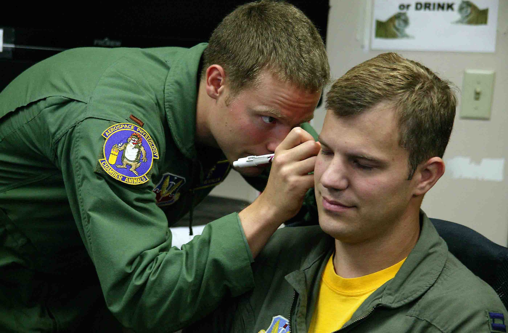 2nd Lt. Chris Reichlen (left) inserts a tube into the ear of Capt. Joe Biedenbach to make an inner-ear mold for the Attenuating Custom Communications Earpiece System Sept. 14 at Shaw Air Force Base, S.C. The ACCES device will significantly reduce surrounding ambient noise that pilots hear in the cockpit and increase the efficiency of radio communications. Lieutenant Reichlen is a 20th Aerospace Medicine Squadron aerospace physiologist, and Captain Hand is a 79th Fighter Squadron F-16 Fighting Falcon pilot. (U.S. Air Force photo/Senior Airman John Gordinier) 
