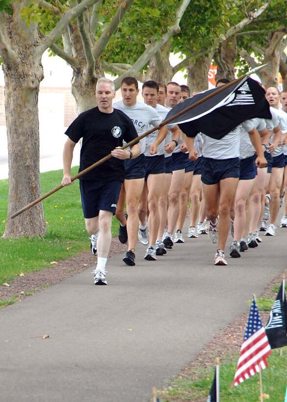 Col. Matthew Bartlett, Air Force Operational Test and Evaluation Center Vice Commander, carries the POW/MIA flag and leads runners during the inaugural lap of the 5th Annual POW/MIA 24-Hour Vigil Run held at Kirtland AFB, N.M., Sept. 20-21.