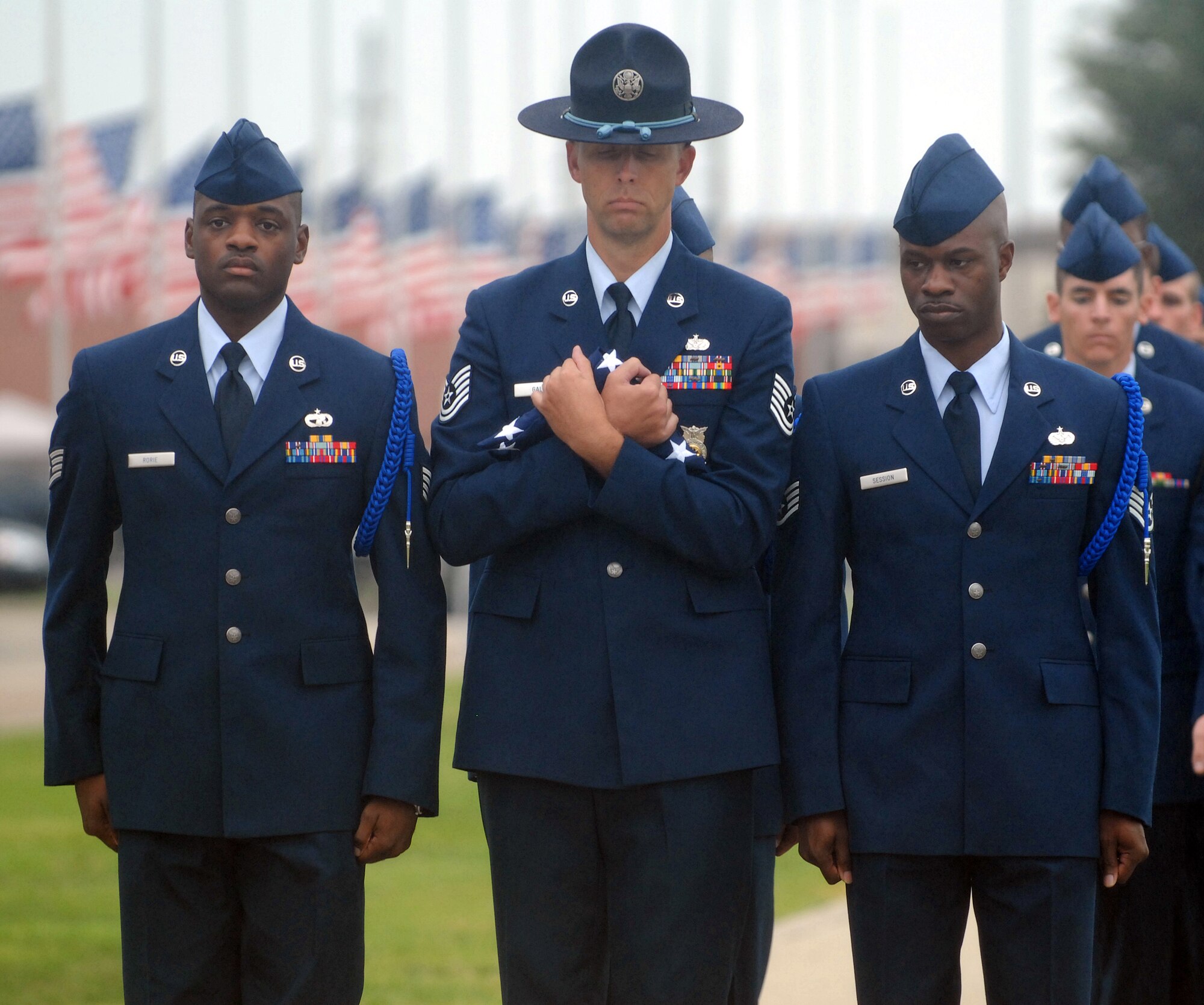 Staff Sgt. Woodrow Rorie, Tech. Sgt. Bobby Gale and Staff Sgt. Jonathan Session solemnly carry the American Flag during a tattoo ceremony honoring the victims of the September 11, 2001 attacks on the World Trade Center and the Pentagon and the passengers of United Airlines Flight 93. (U.S. Air Force photo by Tech. Sgt. Gina O’Bryan)
