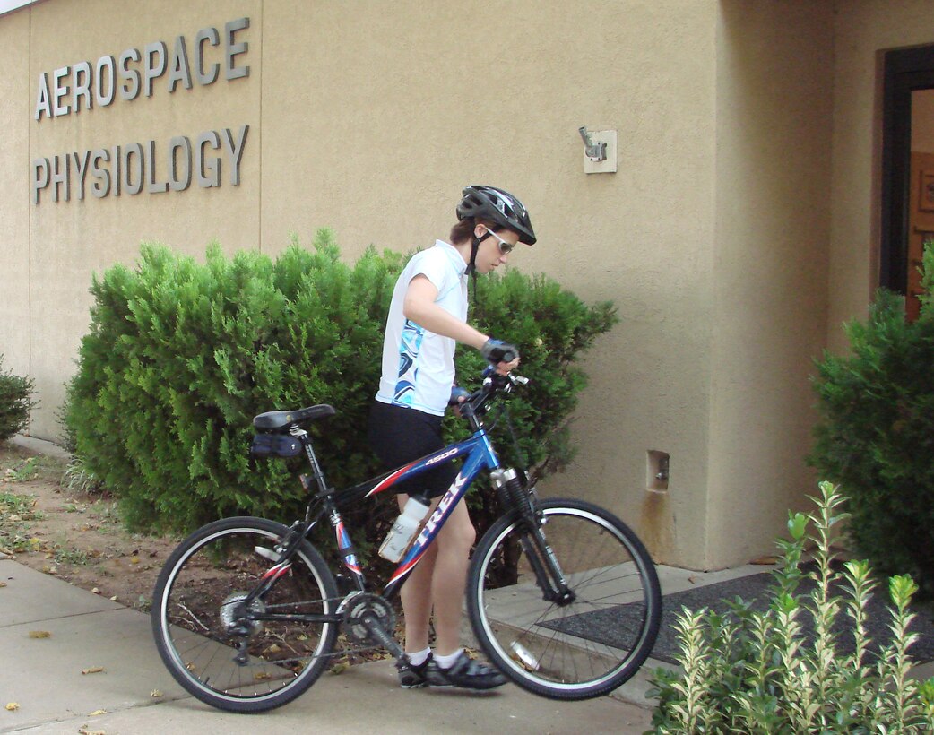 Capt. Joy Schaubhut, 71st Medical Operations Support Squadron aerospace physiologist, arrives for work Monday for the start of a month-long program of bike only transportation. (US Air Force photo/Frank McIntyre)
                              