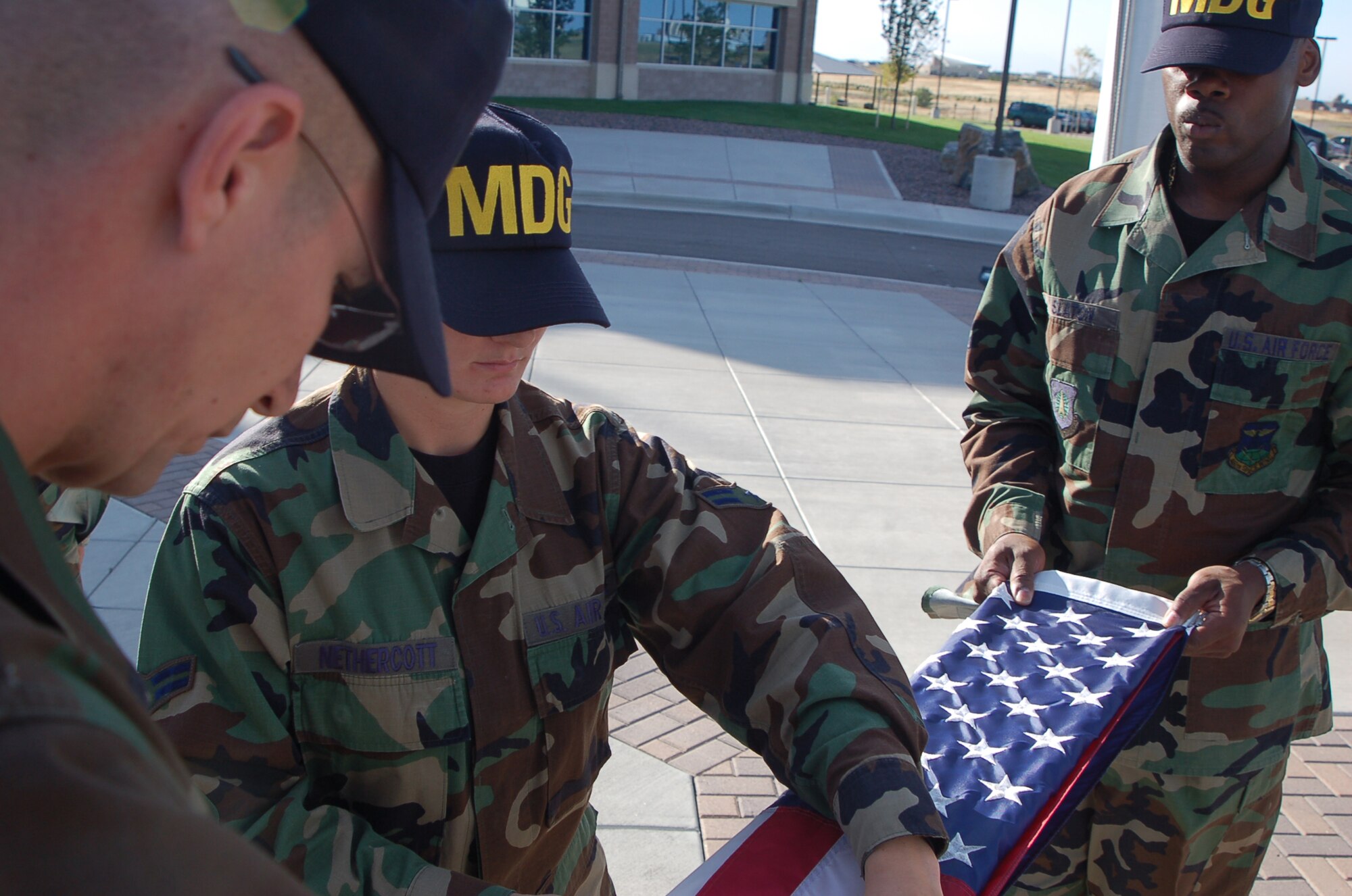 BUCKLEY AIR FORCE BASE, Colo. -- Master Sgt. Frank Graziano, Airman 1st Class Ashley Nethercott and Tech. Sgt. Reggie Slaton, all from the 460th Medical Group, fold the flag during the POW/MIA Recognition Day retreat ceremony Sept. 21. Tech. Sgt. Yolanda Becker, from the 460th Medical Group, organized the Air Force Sergeants' Association-sponsored event. (U.S. Air Force photo by Senior Airman Jacque Lickteig)