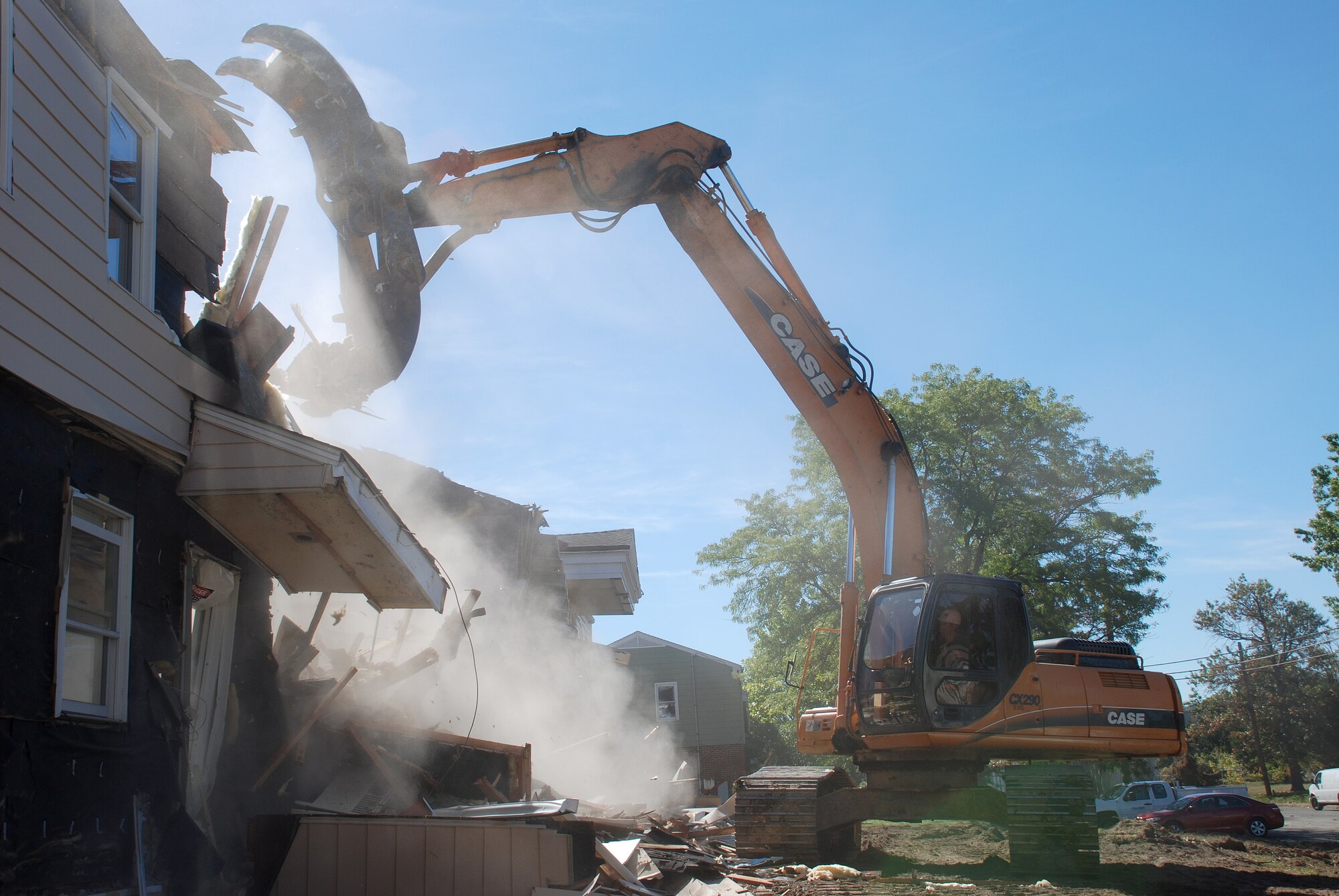 Col. Mike Polhemus, 305th Air Mobility Wing director of staff, begins demolition in the Falcon Courts East housing area Sept. 24. The old housing is being demolished to make way for new housing units. (U.S. Air Force photo/Senior Airman Danielle Johnson)