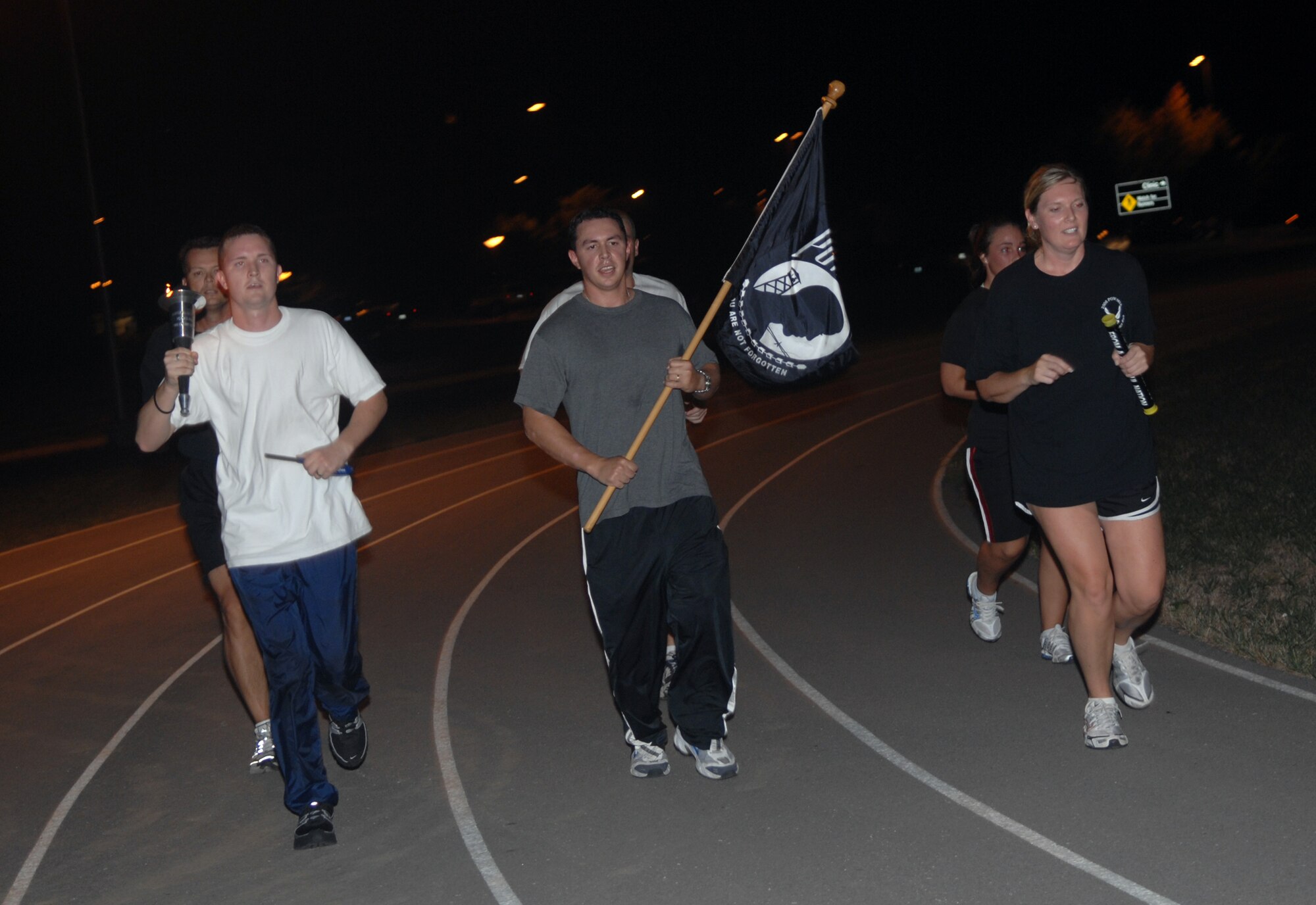 WHITEMAN AIR FORCE BASE, Mo. -- Members of the 509th Bomb Wing Staff carry the torch into the night during the 2007 POW/MIA Remembrance Day Vigil Run Sept. 20 at the base track.  The 24-hour run began Sept. 20 at 4 p.m. and culminated Sept. 21 with a formal retreat to honor those who have sacrificed for this country. (U.S. Air Force photo/Airman 1st Class Cory Todd)