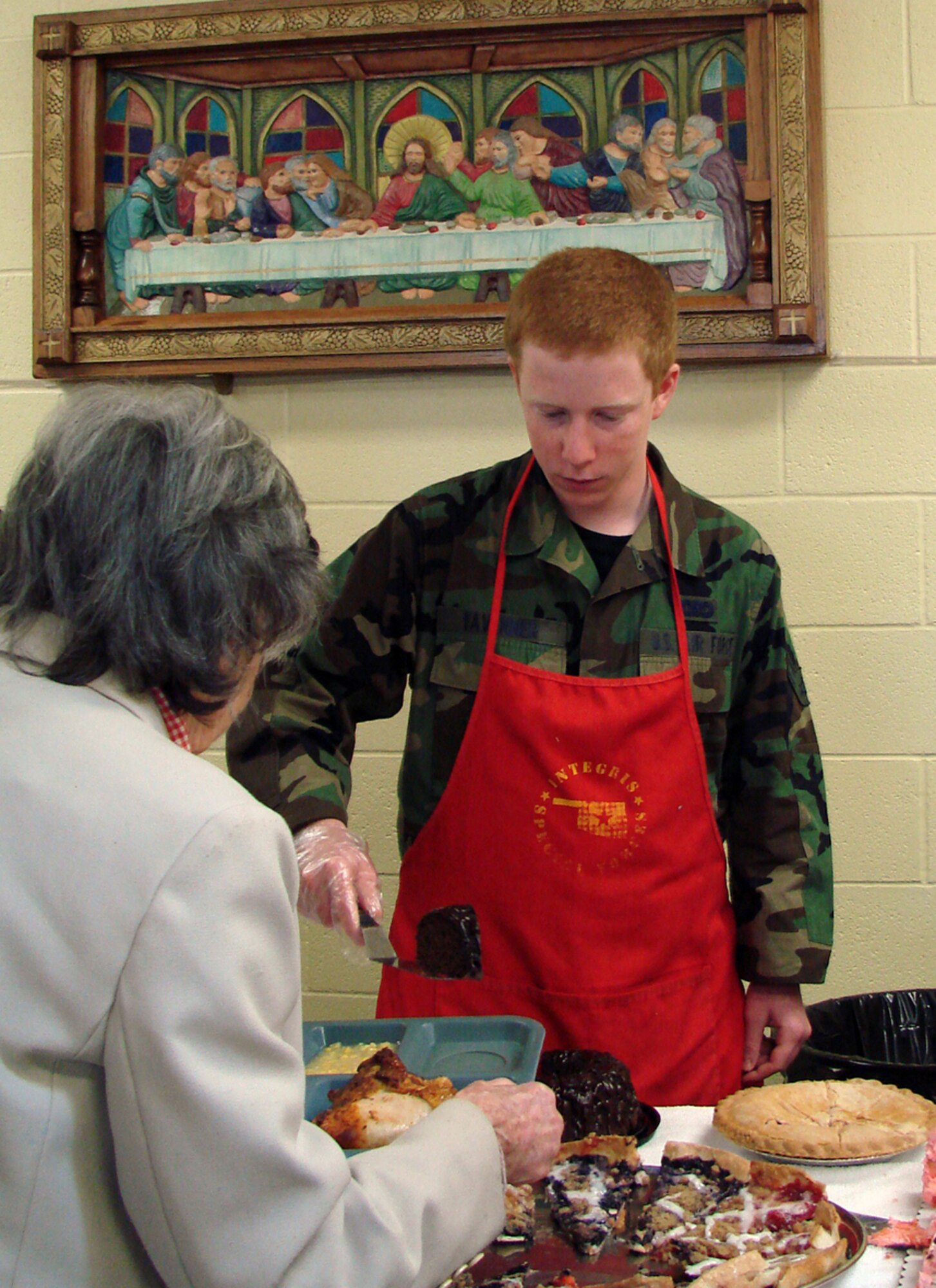 Airman 1st Class Christopher Tavenner, a First Term Airman’s Course student at Vance Air Force Base, serves up a slice of cake to an Enid resident at the Daily Bread. AirmanTavenner is one of seven FTAC Airmen who donated four hours to provide assistance to the local soup kitchen. (US Air Force photo by Senior Master Sgt. Joe Davis)                         