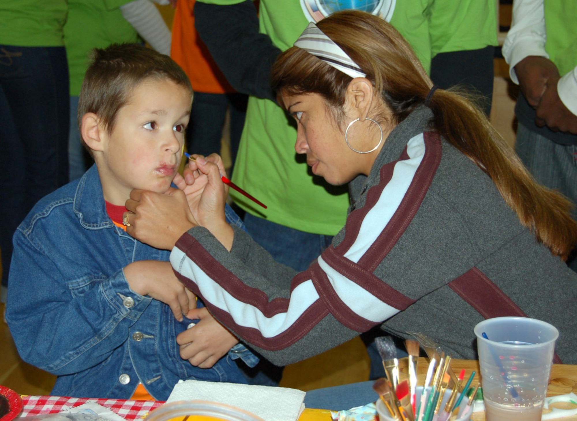 SPANGDAHLEM AIR BASE, Germany – Members of the 606th Spouses Group paint the hands, arms and faces of students during Special Children’s Day, a day for special needs students from Bitburg’s St. Martin’s School and local Department of Defense Schools Sept. 20. (U.S. Air Force photo/Staff Sgt. Tammie Moore)