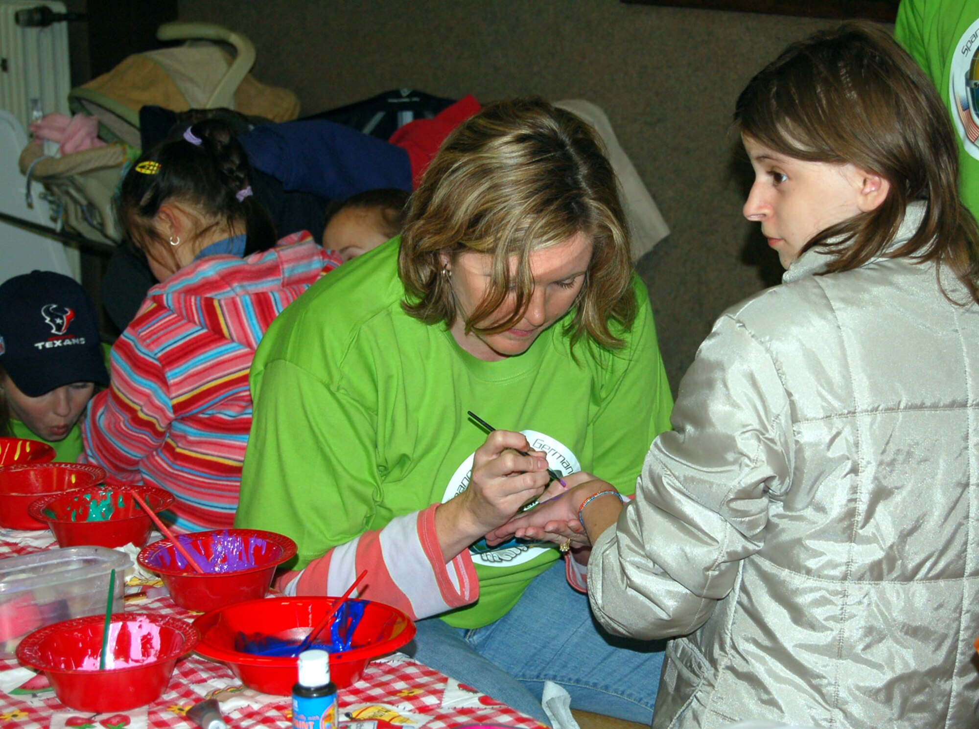 SPANGDAHLEM AIR BASE, Germany – Members of the 606th Spouses Group paint the hands, arms and faces of students during Special Children’s Day, a day for special needs students from Bitburg’s St. Martin’s School and local Department of Defense Schools Sept. 20. (U.S. Air Force photo/Staff Sgt. Tammie Moore)