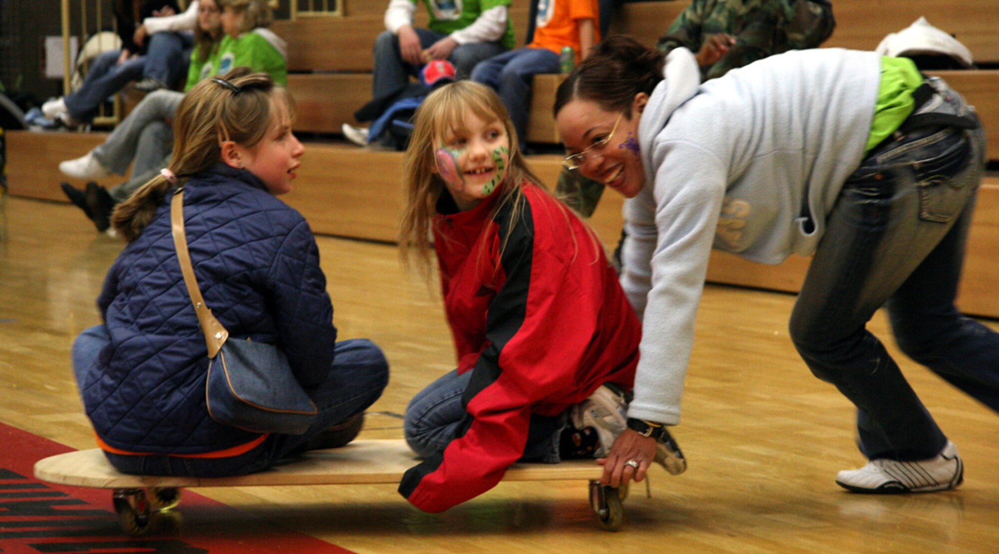 SPANGDAHLEM AIR BASE, Germany – A volunteer pushes students around the gymnasium during Special Children’s Day for special needs students from Bitburg’s St. Martin’s School and local Department of Defense Schools Sept. 20. The day featured events ranging from bean a bag toss to a balance beam walk, a musical performance, a basketball competition, an American style lunch and closed with an awards ceremony.  (U.S. Air Force photo/Capt. Lisa Barber)
