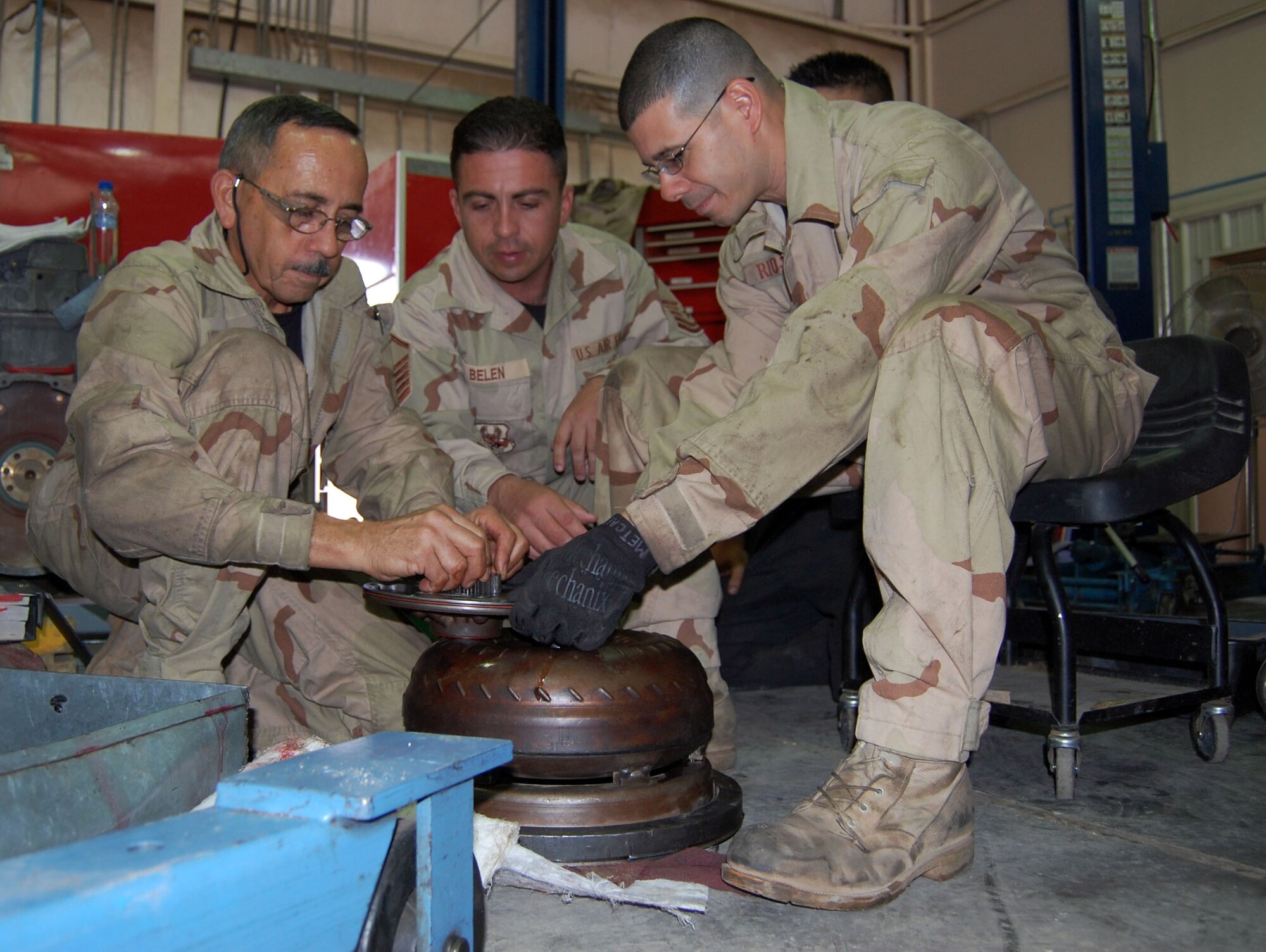 Left: Tech. Sgt. Neftali Vallelopez, Master Sgt. Santiago Belen and Senior Airman Carlos Rios, 386th Expeditionary Logistics Readiness, vehicle maintenance technicians, examine the gearing of a transmission pump plate for defects Sept. 24 in the transportation garage. The pump late is one piece in a long list of parts found in a transmission. (Photo by Staff Sgt. Phillip Butterfield)