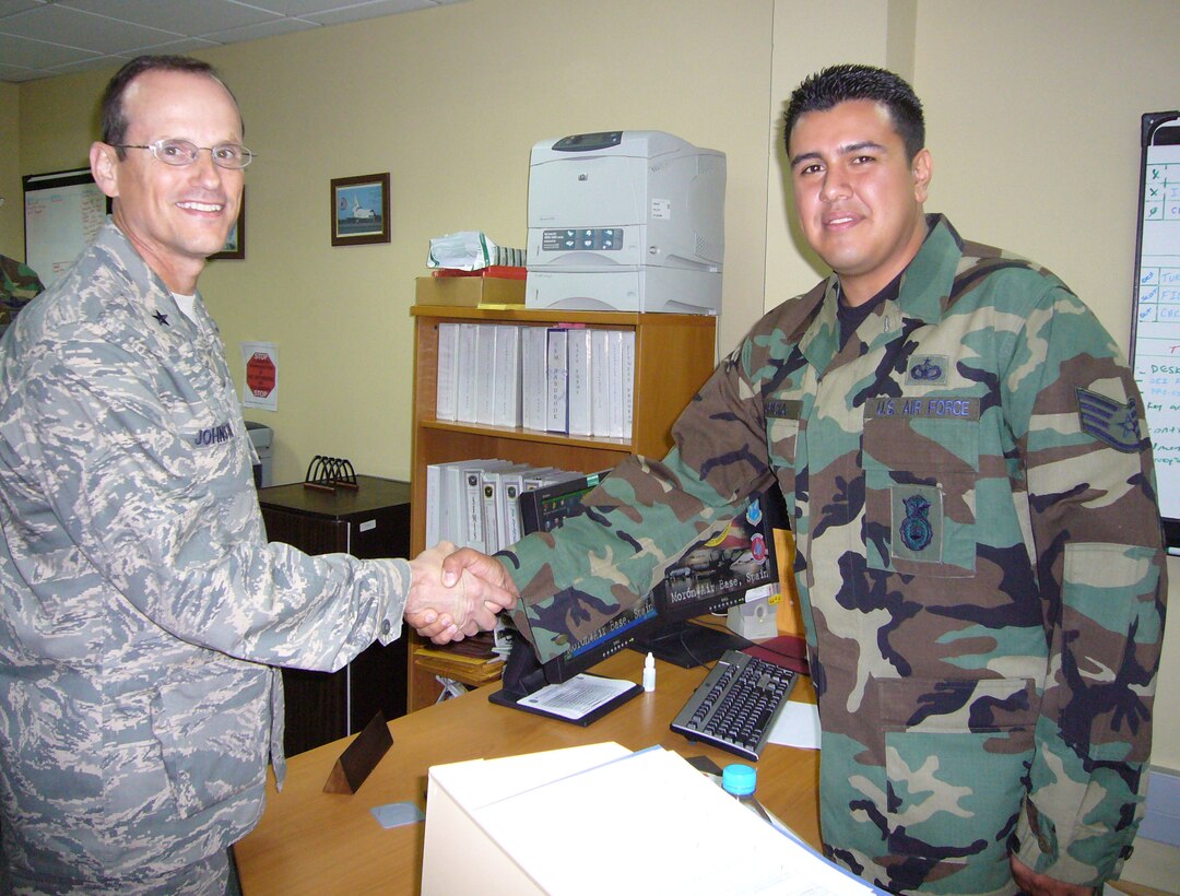 Brig. Gen. Rich Johnston, KMC and 86th Airlift Wing commander, gives one of his coins to Staff Sgt. Jeffrey Garcia, 496th Air Base Squadron security forces, at Morón Air Base, Spain, Sept. 20 for Sergeant Garcia’s accomplishments and hard work.  

