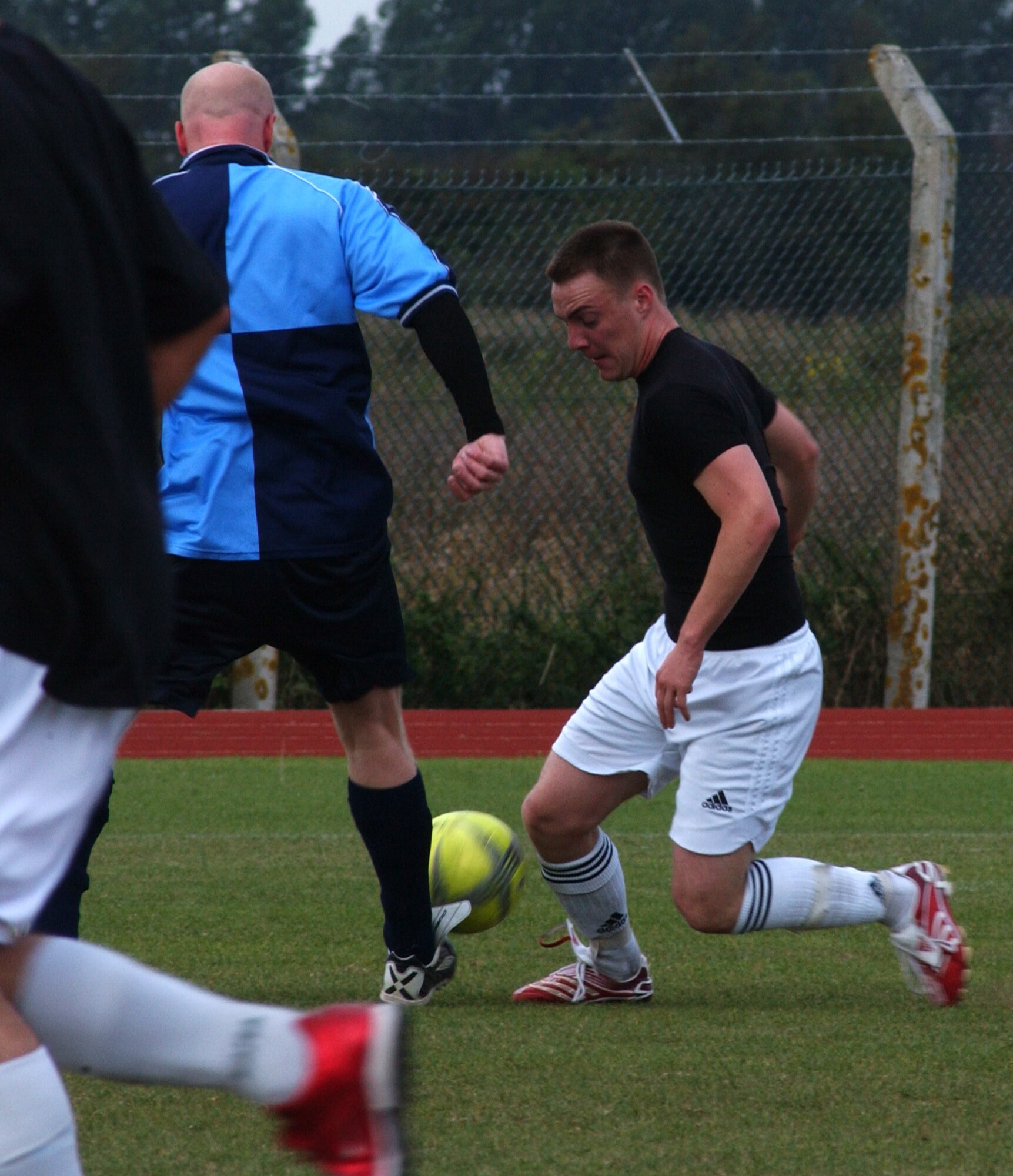 William Nicholson (black shirt), 100th Logistics Readiness Squadron tackles Lee Becker from the 95th Reconnaissance Squadron. The 95th RS defeated the 100th LRS 3-2 in outdoor intramural soccer at RAF Mildenhall, Sept. 19.