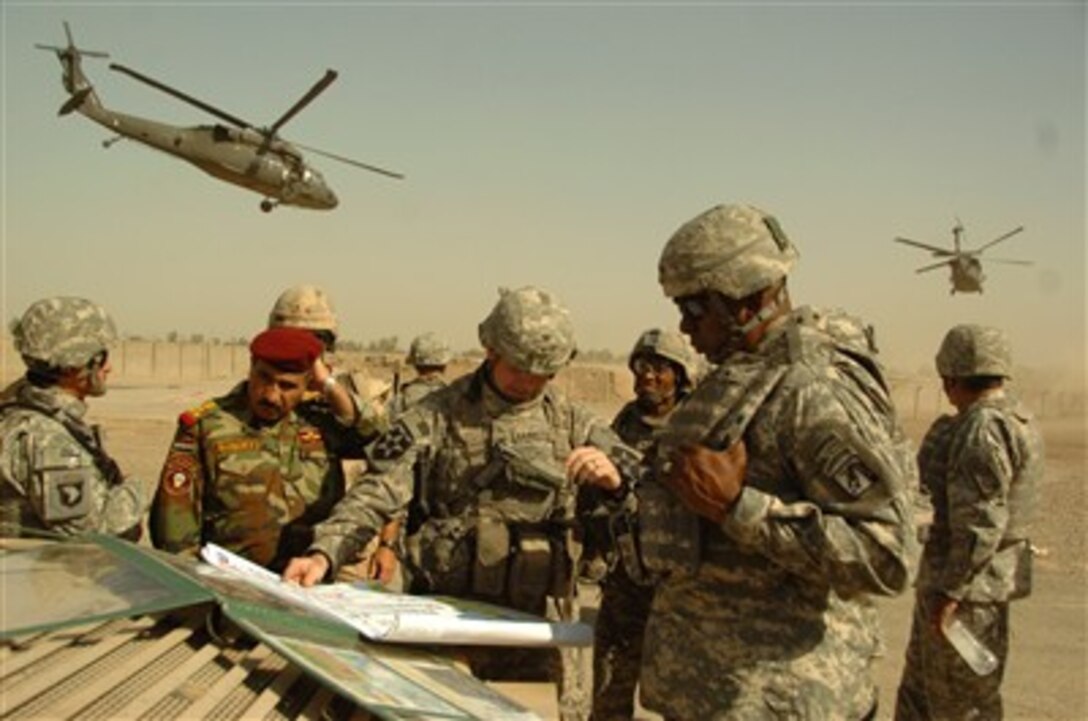 U.S. Army Lt. Gen. Lloyd J. Austin III (right), conmiander of the XVIII Airborne Corps, Col. Jeffrey L. Bannister (center), commander of the 2nd Infantry Brigade Combat Team and Iraqi Brig. Gen. Abdulah (left) discuss troop progress during a field meeting outside Baghdad, Iraq, on Sept. 11, 2007. 