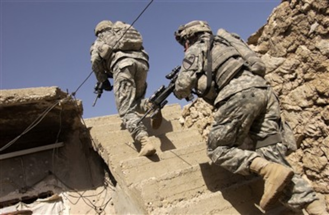 Soldiers of Alpha Troop, 27th Cavalry Regiment, 4th Brigade Combat Team, run up the staircase of a building to establish over watch positions during a mission in Mosul, Iraq, on Sept. 19, 2007. 