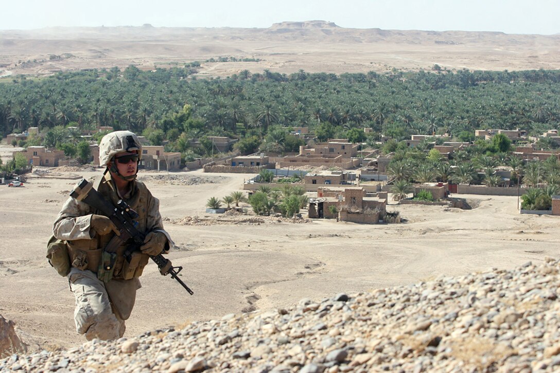 EXPEDITIONARY PATROL BASE - DULAB, Iraq, (Sept. 26, 2007) – Pfc. Phrank V. Aguirre, an infantryman with Company A, 1st Battalion, 7th Marine Regiment, Regimental Combat Team 2, crests a large hill on the outskirts of town during one of the company’s long foot patrols. The Marines of Company A, known as the “Animals,” spend most of their time on foot patrols in or around the city, or in over watch positions for Iraqi Security Forces. Official Marine Corps Photo By Cpl. Ryan C. Heiser.