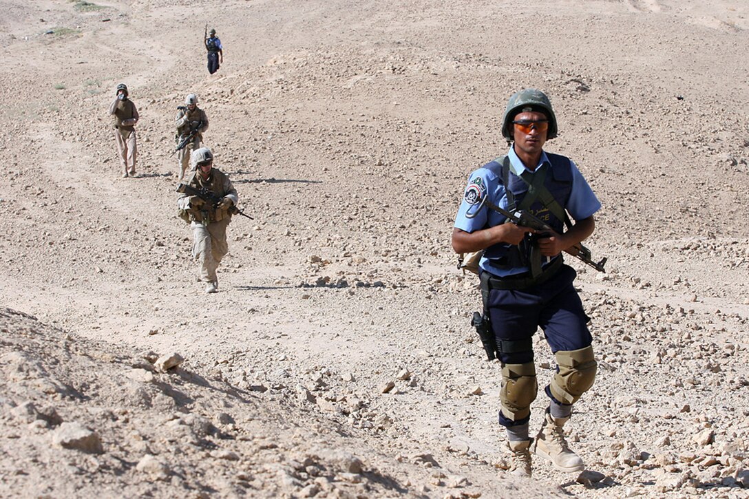 EXPEDITIONARY PATROL BASE - DULAB, Iraq, (Sept. 26, 2007) – An Iraqi policeman glances up while on a joint patrol with Marines from 1st Platoon, Company A, 1st Battalion, 7th Marine Regiment, Regimental Combat Team 2. The company, known as the Animals, frequently goes on patrols lasting more than six hours, and regularly covers a dozen miles each day. Official Marine Corps Photo By Cpl. Ryan C. Heiser.