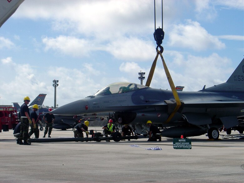 Tech. Sgt. Tim Sabelfeldt (red hat, center), deployed crash recovery team chief, coordinates recovery operations for this F-16. The Fighting Falcon experienced a nose landing gear failure. Sergeant Sabelfeldt and his team of specialists are responsible for ensuring the aircraft is recovered methodically and safely so it can be restored to duty status. The crane is just one of many tools the team must learn to use in any highly technical and complex recovery operation. (Courtesy photo)                           