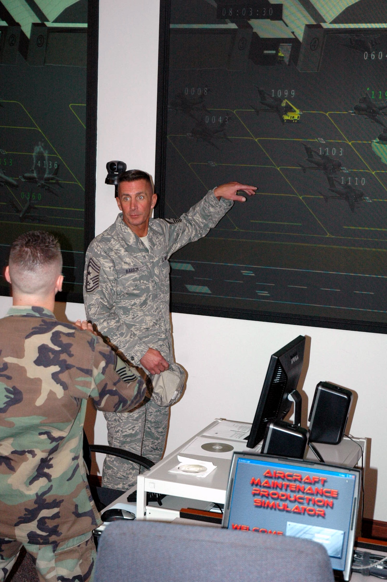 Master Sgt. Richard Woods, U.S. Air Force Expeditionary Center Mobility Operations School, talks to Chief Master Sgt. Joseph Barron Jr., Air Mobility Command's command chief master sergeant, about the new aircraft maintenance production simulator to be used by the MOS for classroom instruction Sept. 18, 2007, at the Center on Fort Dix.  Chief Barron was making an official visit to the Center from AMC.  (U.S. Air Force Photo/Tech. Sgt. Scott T. Sturkol)