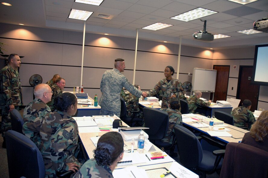 Chief Master Sgt. Joseph Barron Jr., Air Mobility Command's command chief master sergeant, shakes hands with Staff Sgt. Khadejah Mitchell, instructor with the U.S. Air Force Expeditionary Center's Mobility Operations School, during a visit to her classroom Sept. 18, 2007, at the Center on Fort Dix, N.J.  Chief Barron was making an official visit to the Center and toured classrooms and other areas of the Center's training complex.  (U.S. Air Force Photo/Tech. Sgt. Scott T. Sturkol)