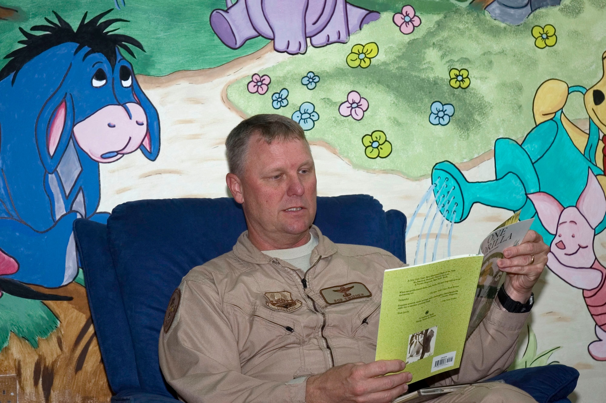Col. Robert Swisher reads the book "One Gorilla" to his grandchildren at the Learning Resource Center Sept. 15 at his deployed location in Southwest Asia. The Read to your Child Program offers deployed members the opportunity to record themselves reading books so their loved ones can watch the video and keep in touch. Colonel Swisher is the 386th Air Expeditionary Wing Commander. (U.S. Air Force photo/Staff Sgt. Tia Schroeder) 